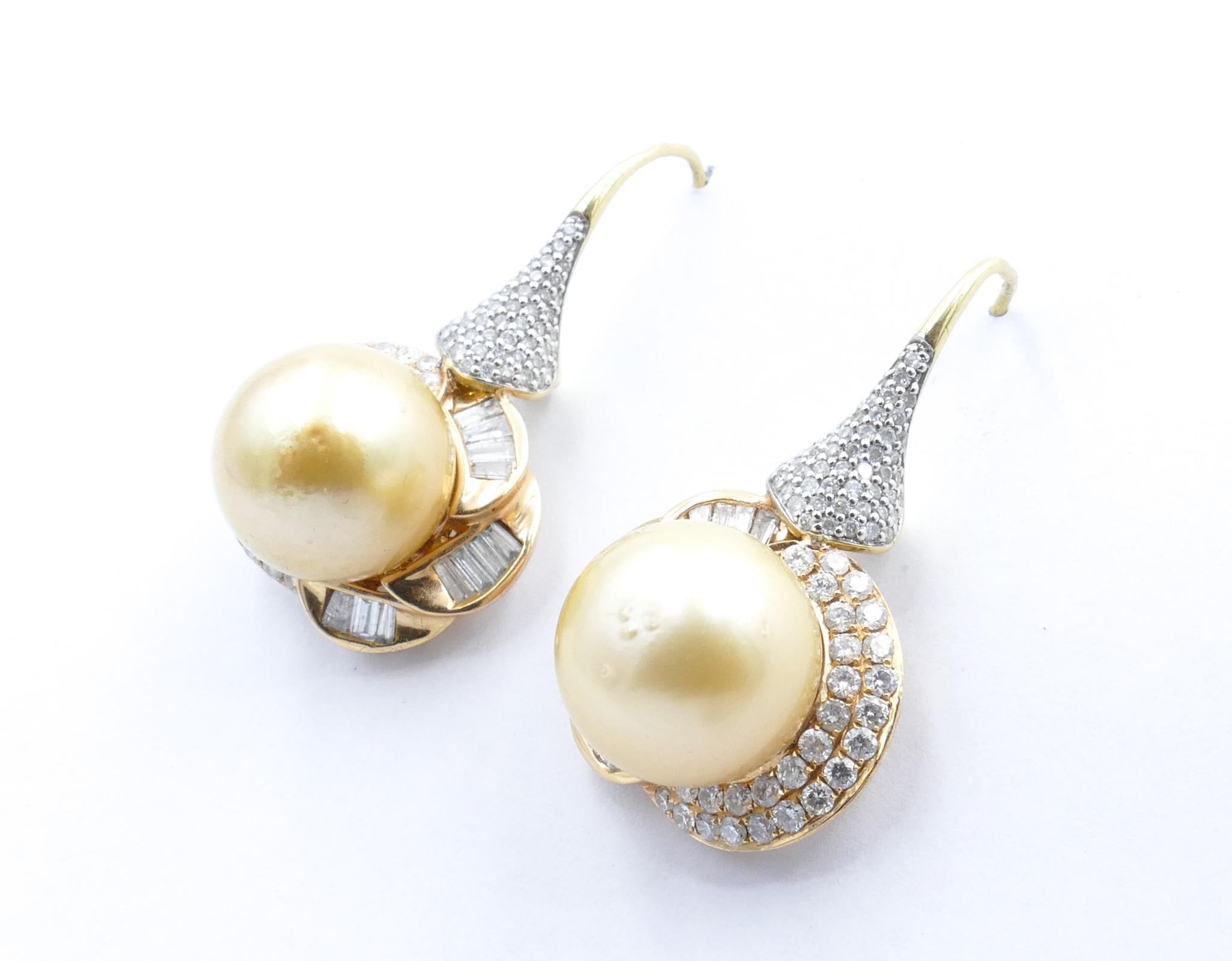 These beautiful Golden Pearl Drop Earrings feature 2 X 13+mm South Sea Pearls surrounded by 134 Brilliant Cut Diamonds, Bead/Pave Set, Colour G/I, Clarity VS1-VS2.
As well there are 24 tapered Baguette Cut Diamonds, channel set, Colour G/I, Clarity
