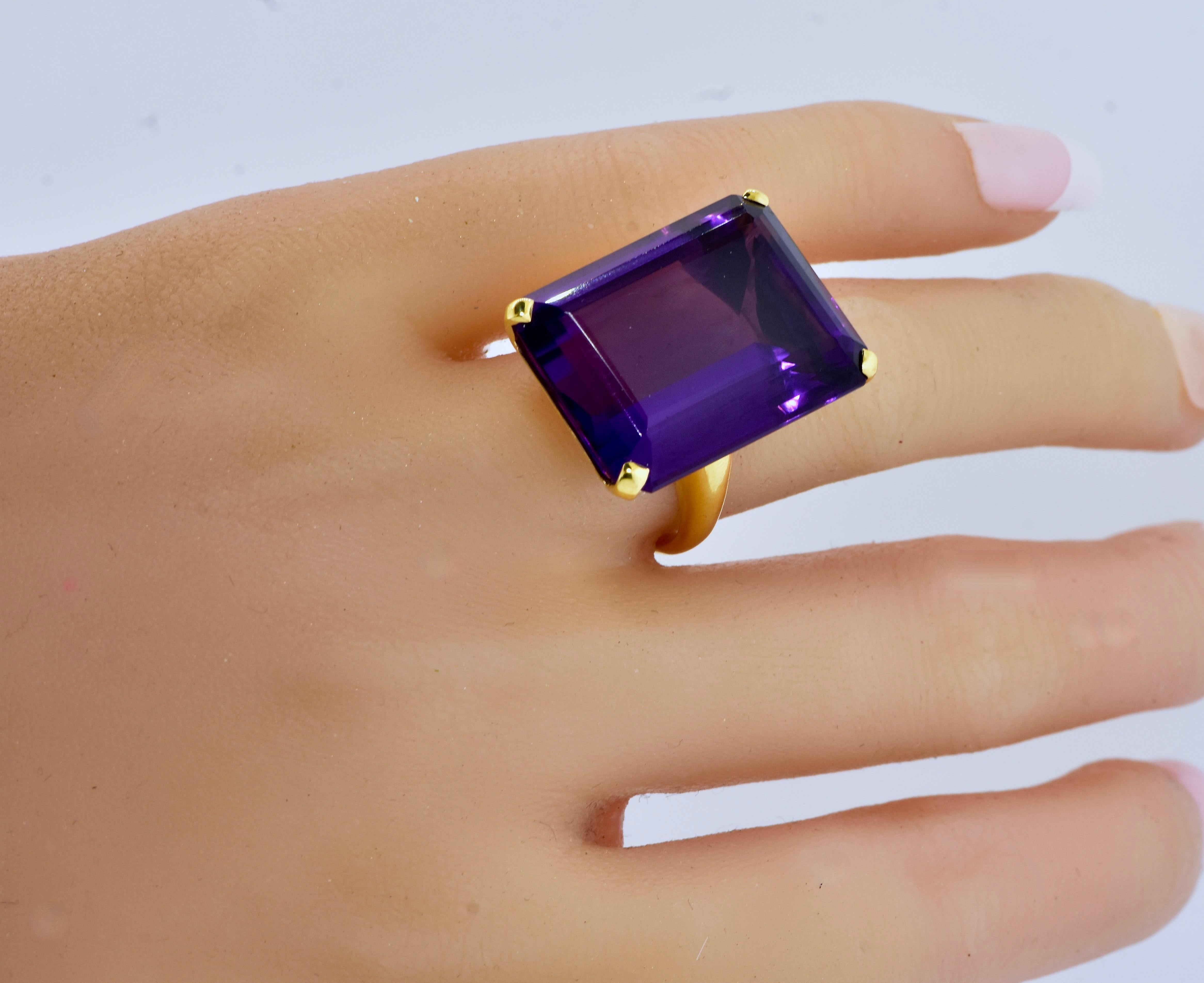 Very fine large emerald cut amethyst displaying a vivid deep purple with flashes of red, this new ring is hand crafted in 18K yellow gold by Pierre/Famille of Aspen, CO.  

The long emerald cut amethyst weighs 36.21 cts.  It is a size 6.5 and can be
