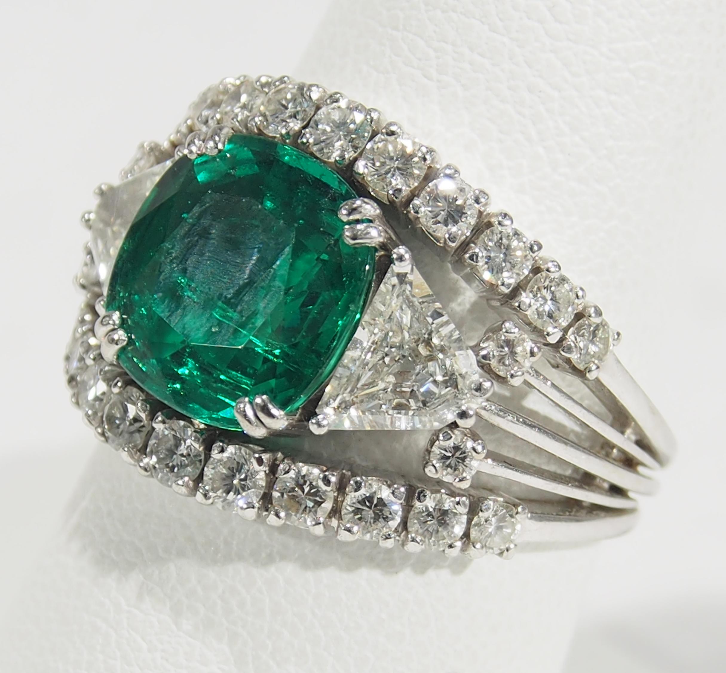 AGL Certified Emerald and Diamond Ring in 18K White Gold. The Center Stone is a Cushion Cut Emerald, approximately 4.0ct, enhanced with (2) Trillion Diamonds and (26) Round Brilliant Cut Diamonds weighing 2.15 carat total weight, G-H in Color, VS in