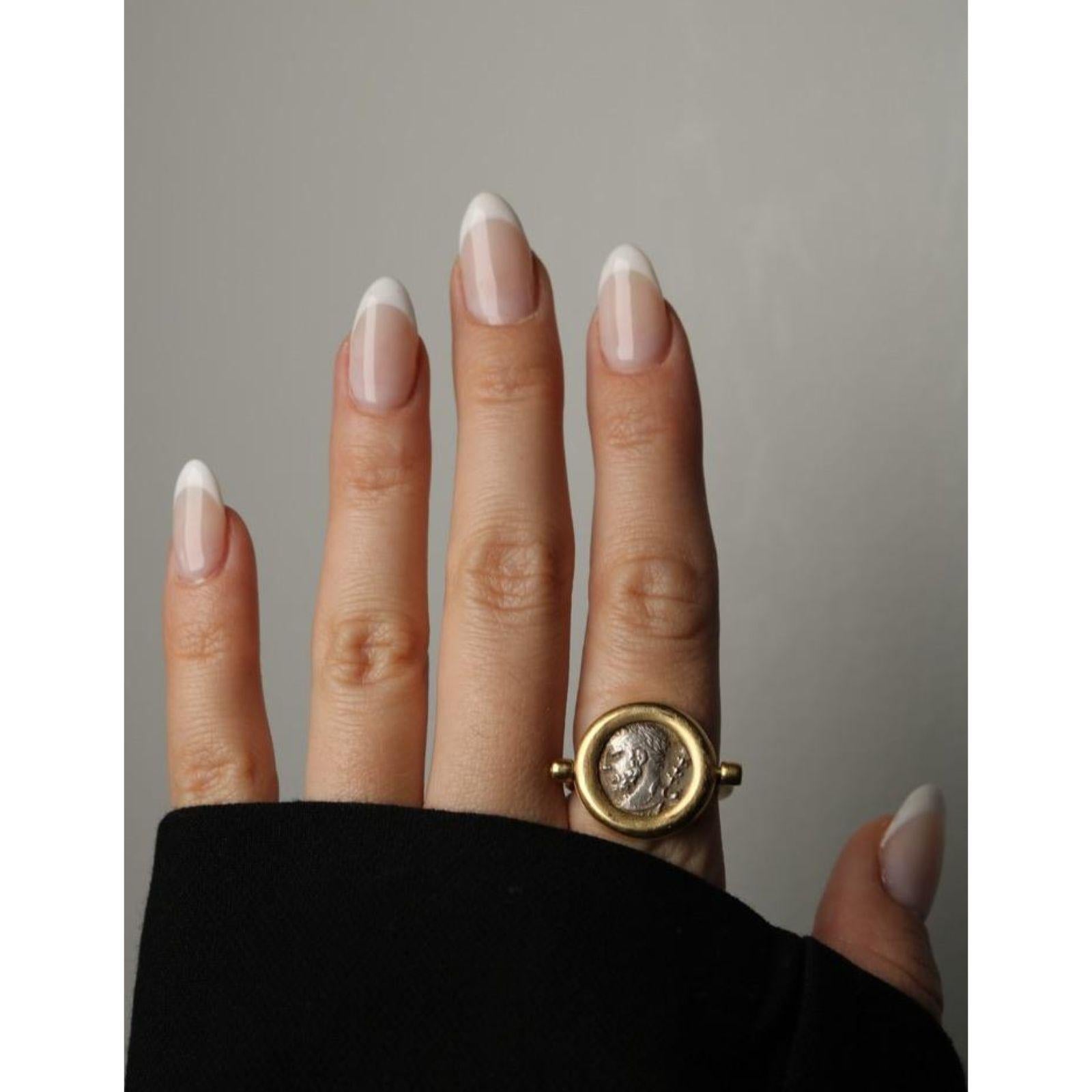 18K Ancient Coin Flip Ring Bezel Set Silver Coin Yellow Gold Size 8.75

Cette bague distinctive présente une pièce de monnaie ancienne sertie dans une monture circulaire lisse en or jaune 18 carats. La surface altérée de la pièce et son profil