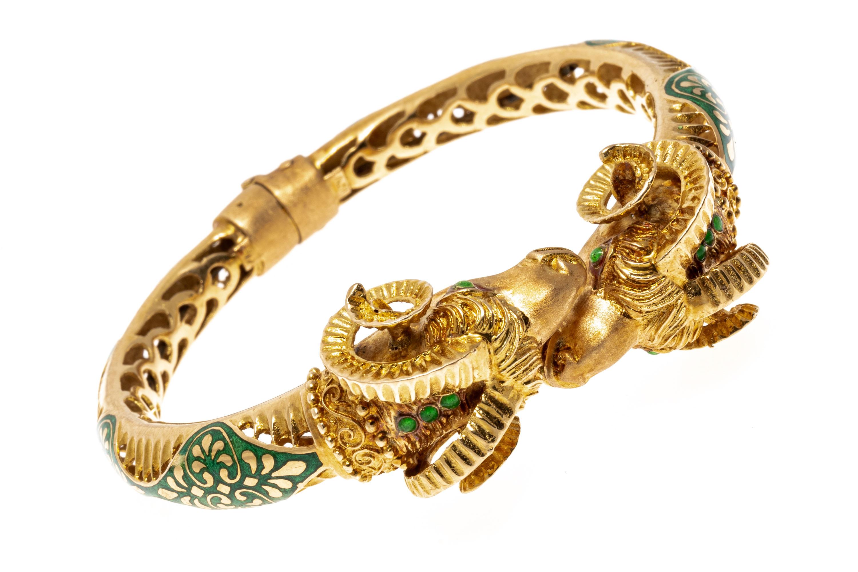 18k Yellow Gold And Green Enamel Bypass Rams Heads Bypass Hinged Cuff Bracelet.
 This beautiful bracelet is a twisted hinged cuff style, with a bypass top of matte finished rams heads. The body of the bracelet is an undulating pattern of alternating