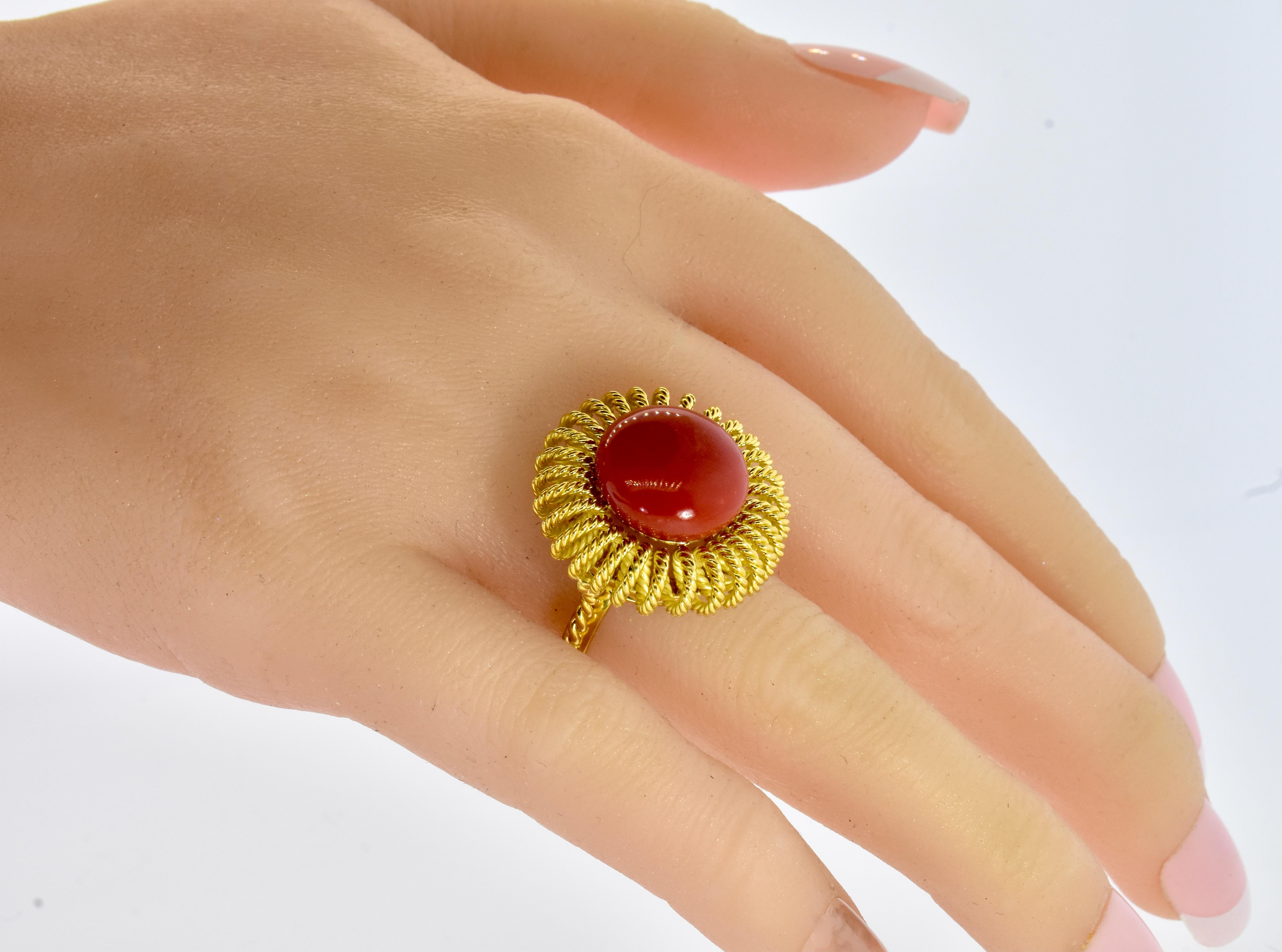 Oxblood red coral and 18K yellow gold vintage ring centering a 14.3 mm. button coral.
The 18K yellow gold ring weighs 17.9 grams, the ring manifest a color that is extremely difficult to find in the market.  In fact, this particular  stone are as