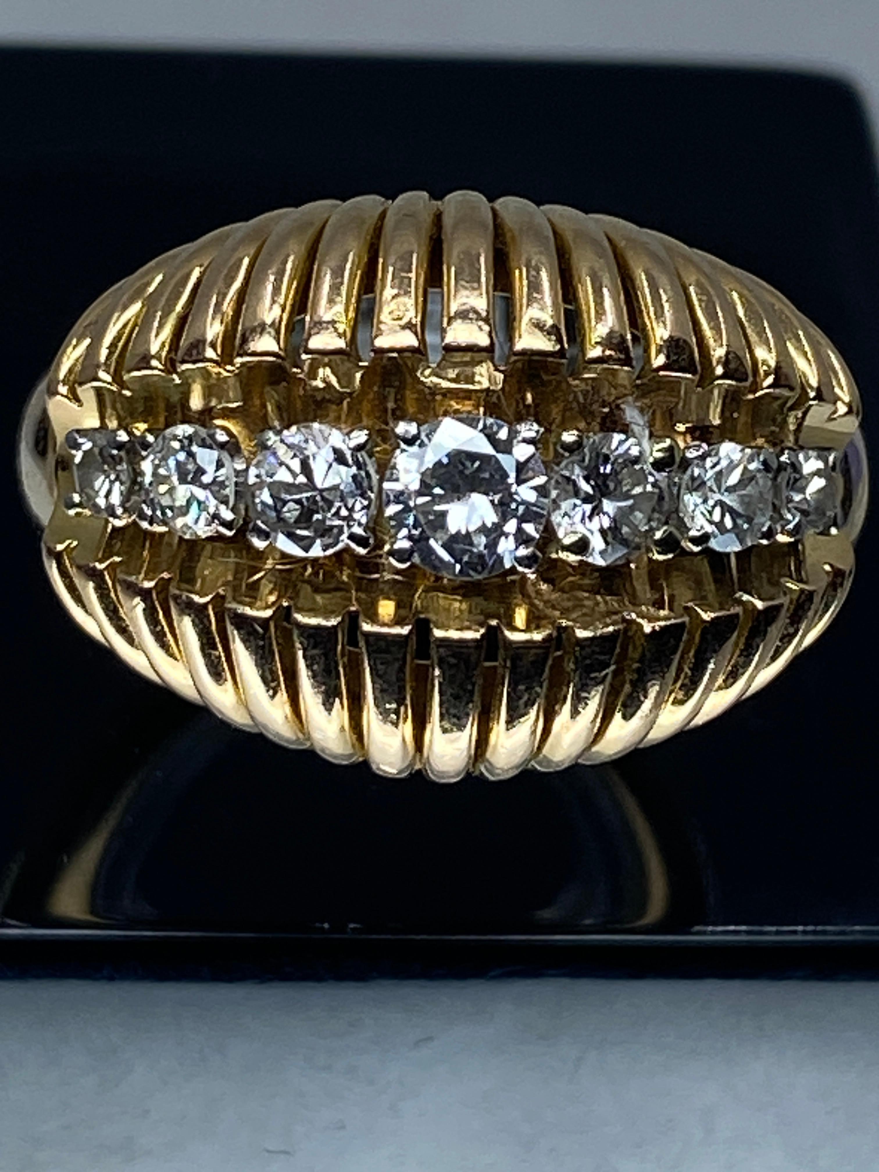 Ravissante bague en or 18 carats de forme jonc bombée, stylisée de fils d'or. Le centre est orné d'une ligne de diamants de taille brillant, poids total des diamants 0.60/0.70 carat environ. Chacun est serti par 4 Griffes en platine. Le charme de