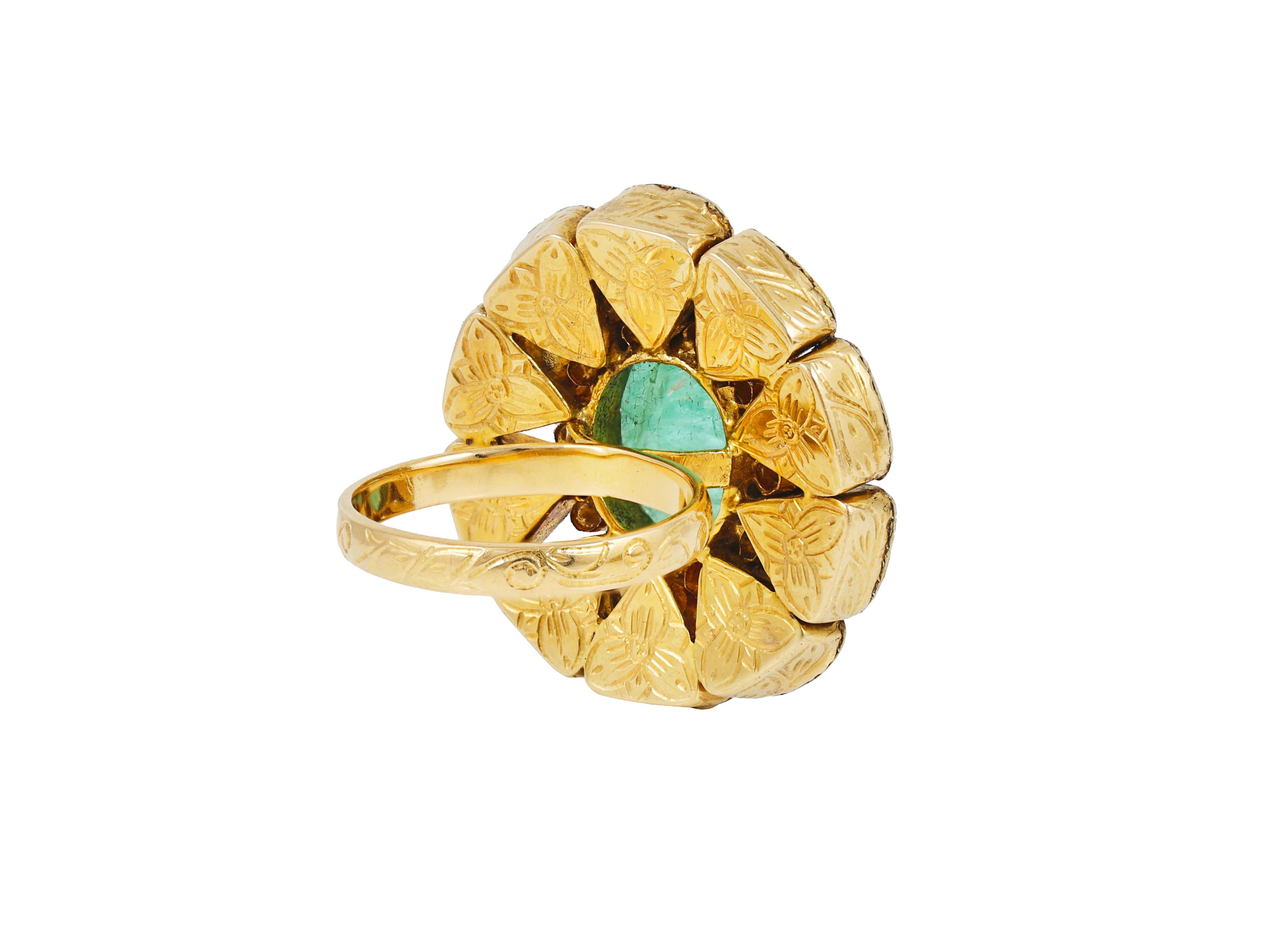 A 18 K gold ring centrally set with faceted Russian emerald of 7.54ct in an open-back gold setting, the band at the side has been meticulously engrave to enhance the beauty of the ring. At the centre the emerald is surrounded by natural full cut
