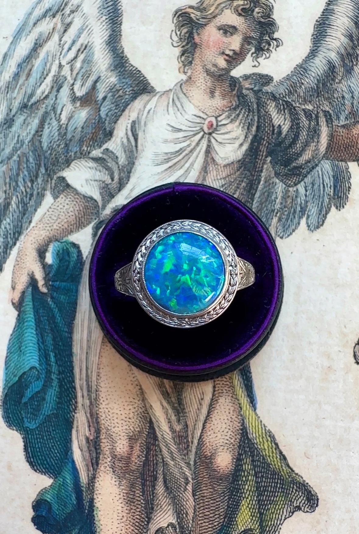 Like seeing the Earth from outer space, this mesmerizing black opal cabochon is filled with iridescent blues, Sunkist orange and neon greens. Masterfully hand fabricated in 18K white gold, the opal is framed by a hand engraved bezel displaying a