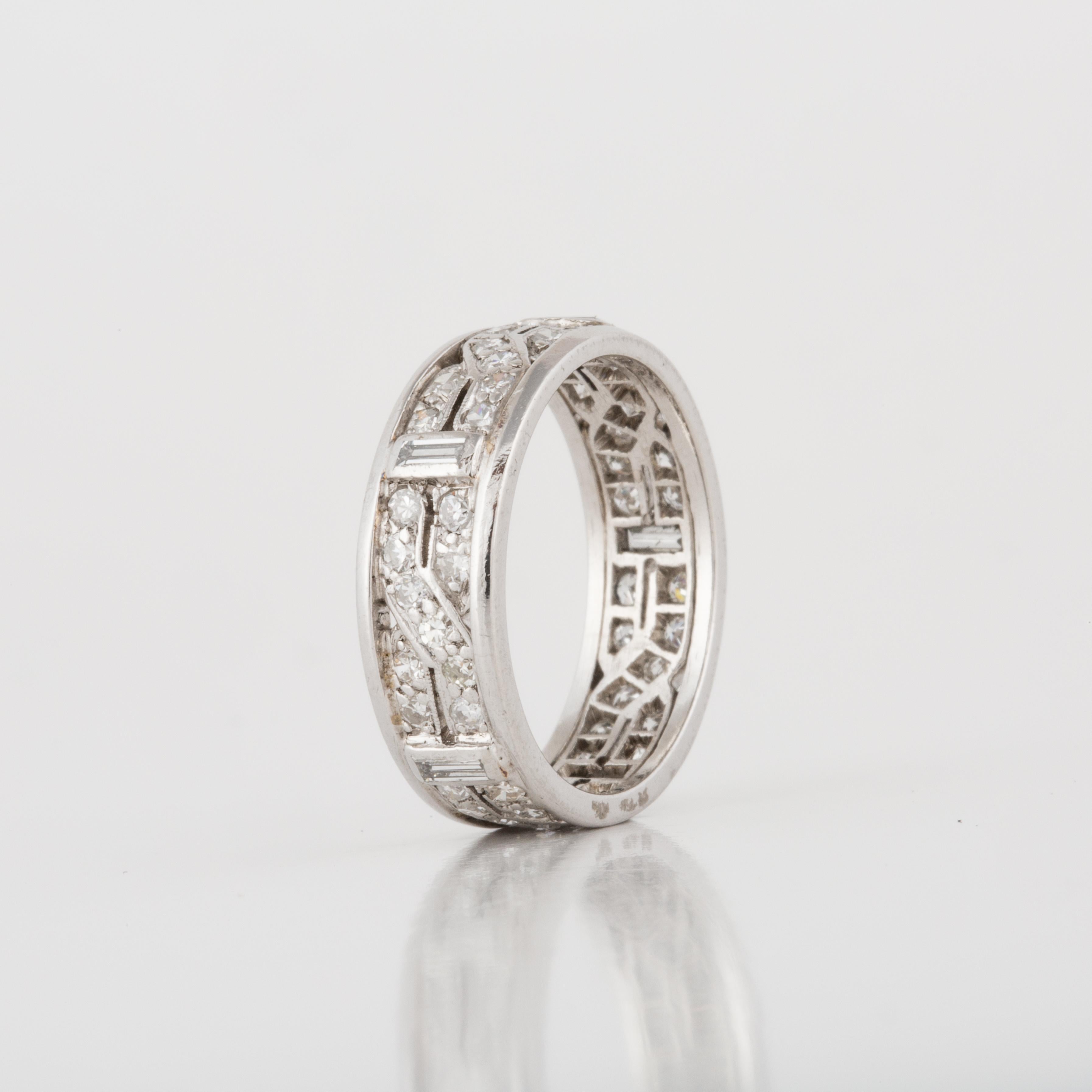 Art Deco eternity band in 18K white gold with diamonds.  The band features 50 single-cut diamonds that total 1.00 carat, and five baguette diamonds that total 0.25 carats.  The ring is a size 6 and measures 1/4 inches wide.