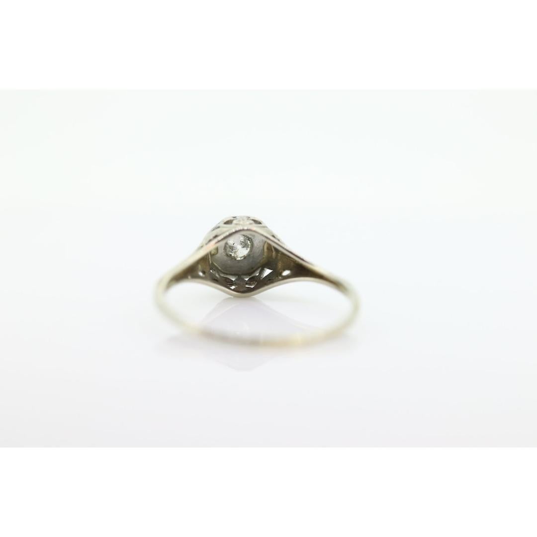 Vintage from the 1920s
Size: 6 1/2 US
Materials: Stone
Gemstone: Diamond
Gem color: Colorless
Band color: Silver

Style: Art deco

Beautiful Filigree ring. 18k white gold. Amazing piece when worn. Engraved with Bowties.

Details:
1.4grams total