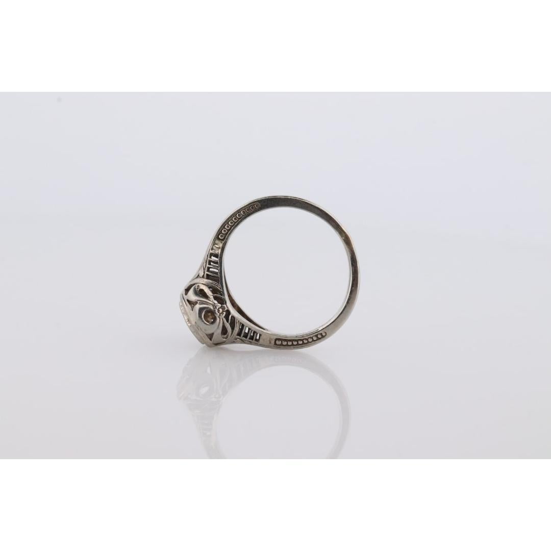Vintage By aus den 1920er Jahren
MATERIALIEN: Stein
Edelstein: Diamant
Edelsteinfarbe: Farblos
Bandfarbe: Silber
Stil: Art deco
Schöner filigraner Ring. 18k Weißgold. Erstaunliches Stück, wenn es getragen wird. Offenes Design

Einzelheiten:
1,7