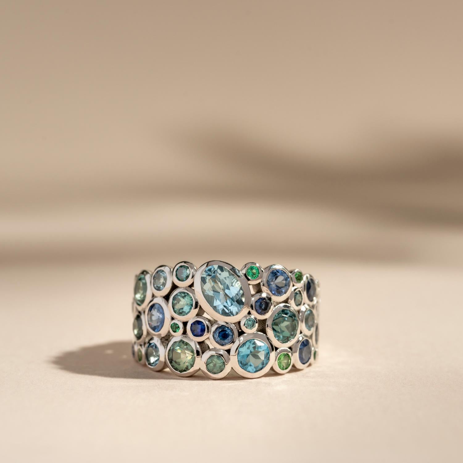 This ring is a one-off 18k white gold teal treasure from a series of Bespoke Cascade rings, each made with individual compositions of gemstones - varying in colours, sizes and types. 

This particular ring features 3.00cts of gemstones in an ombré