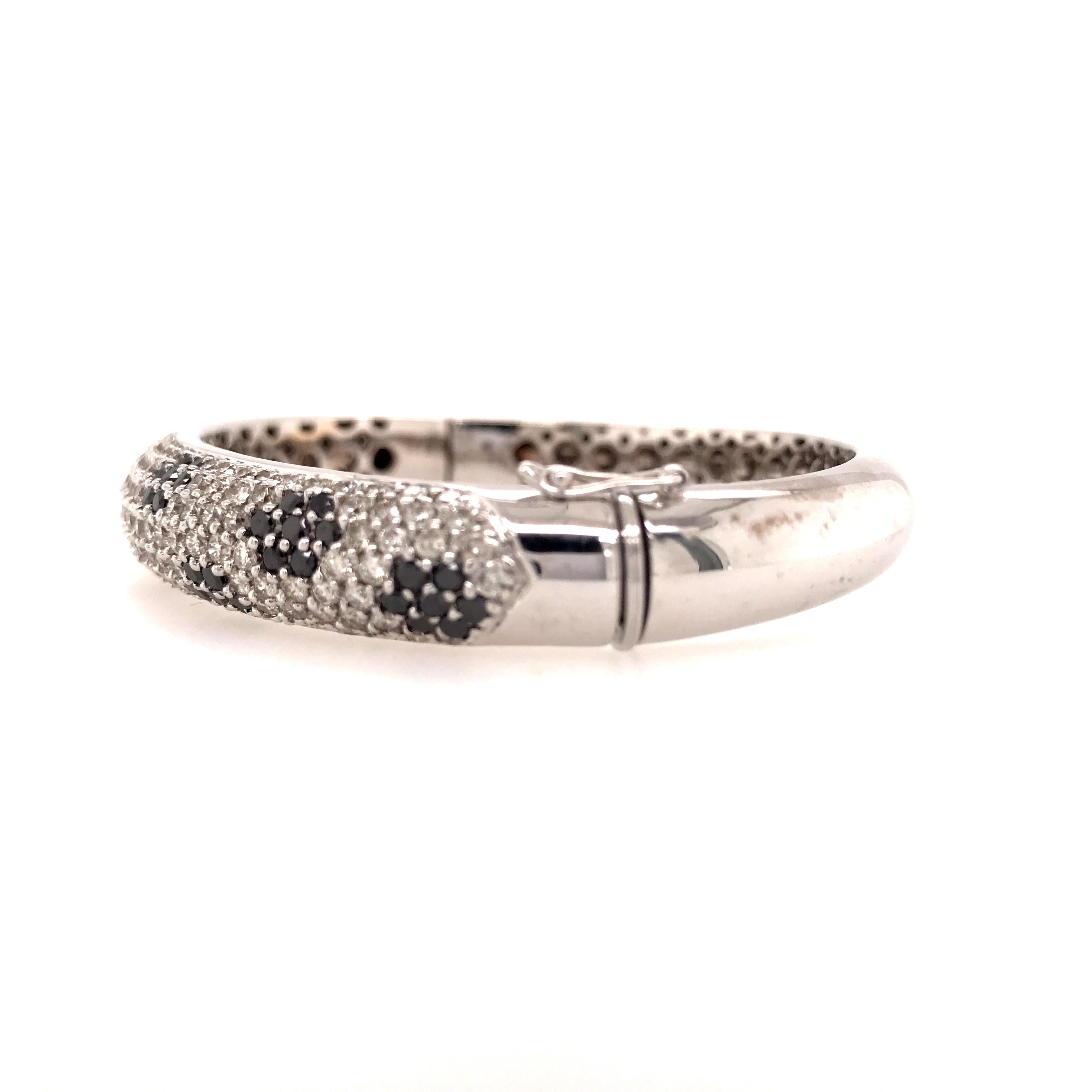 Black and White Diamond Bangle in 18K White Gold.  (70) Round Black Diamonds weighing 3.50 carat total weight and Round Brilliant Cut Diamonds weighing 4.42 carat total weight G-I in color and VS-SI in color are pave set.  The bangle measures 2