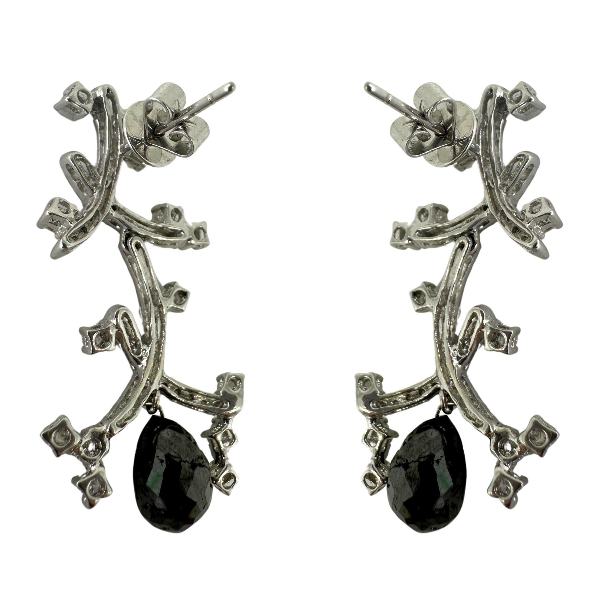 Showcasing these elegant 18k Black and White Diamond Earrings. With a total weight of 6.11 carats, these stunning earrings feature 1.32 carats of dazzling white diamonds and 4.79 carats of deep black diamonds. Crafted in 18k white gold and measuring