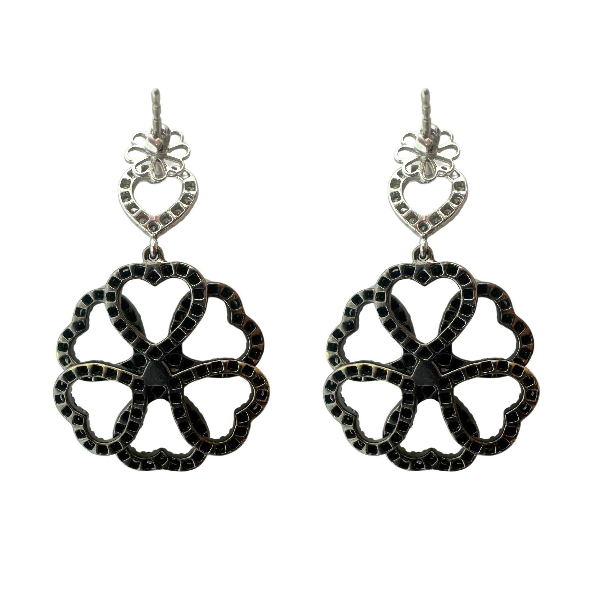 Look at these cute 18k Black and White Diamond Flower Earrings. Crafted in 18k white gold, these earrings feature a total of 5 carats of sparkling diamonds, including 0.66 carats of white diamonds and 4.24 carats of black diamonds. At 1.25 inches in