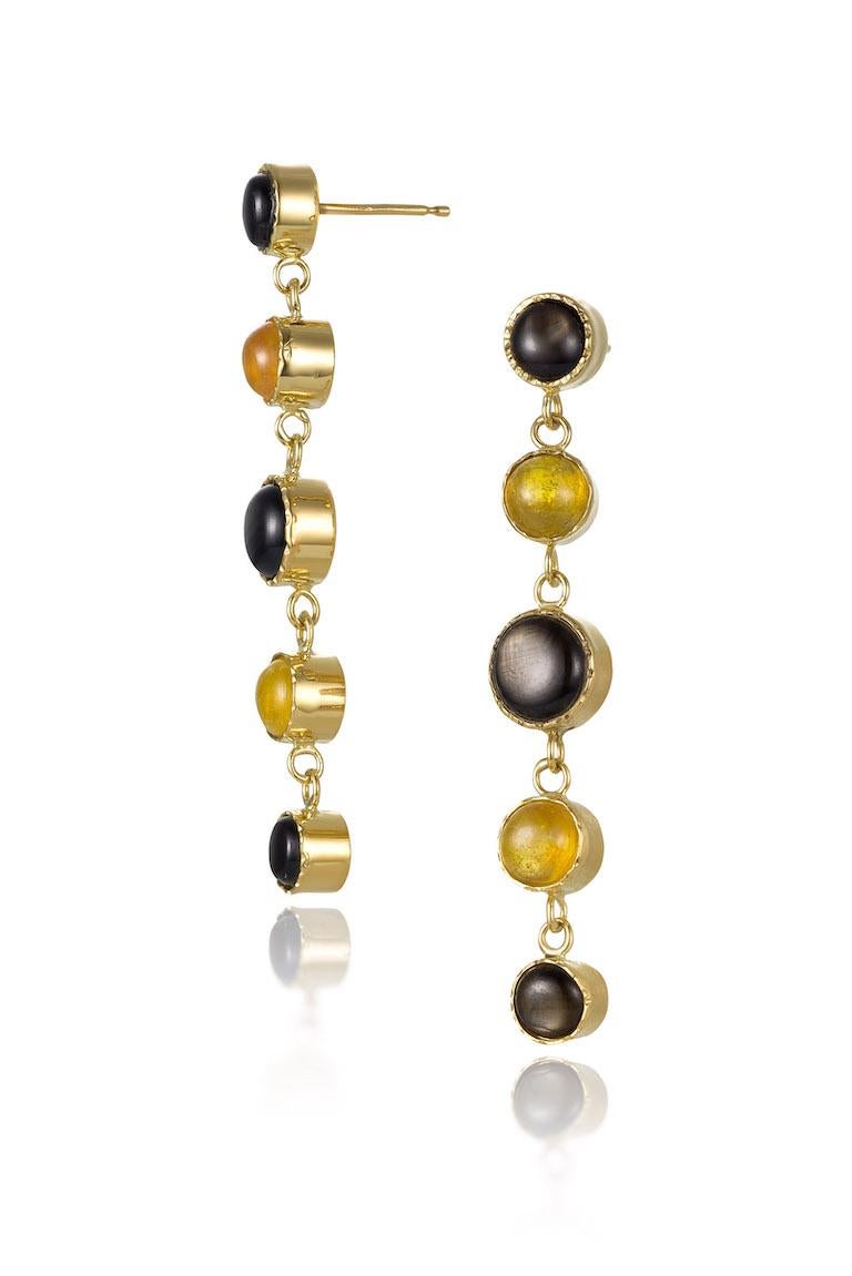 18K yellow gold bezels surround 9.15 carats of black star and yellow sapphire cabochons dots.  These elegant  3
