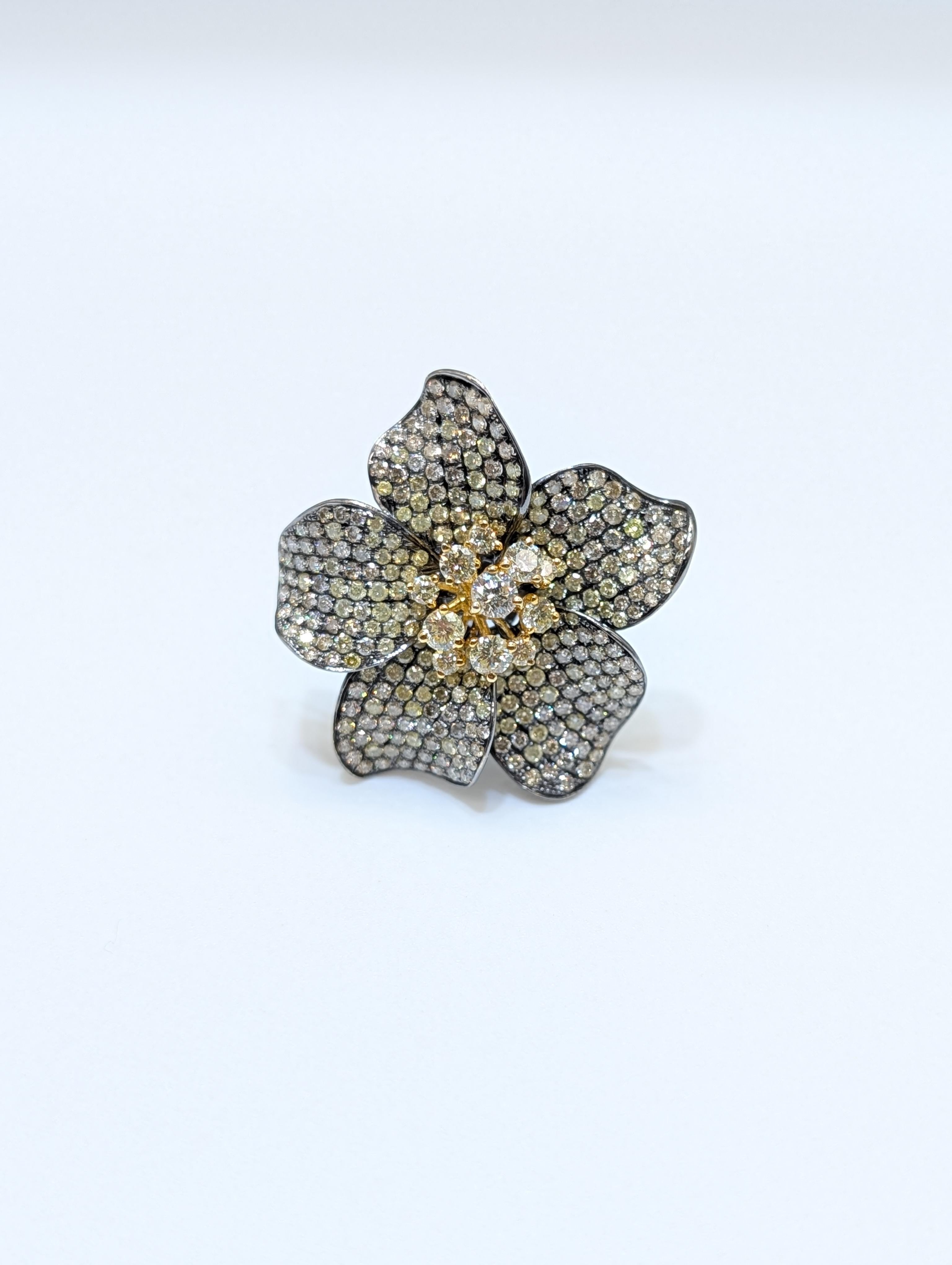 Questo anello con fiore mozzafiato è una vera e propria dichiarazione di eleganza e maestria. Realizzato in oro giallo 18 carati, il design è incentrato su un suggestivo motivo floreale, con diamanti tondi taglio brillante incastonati che adornano