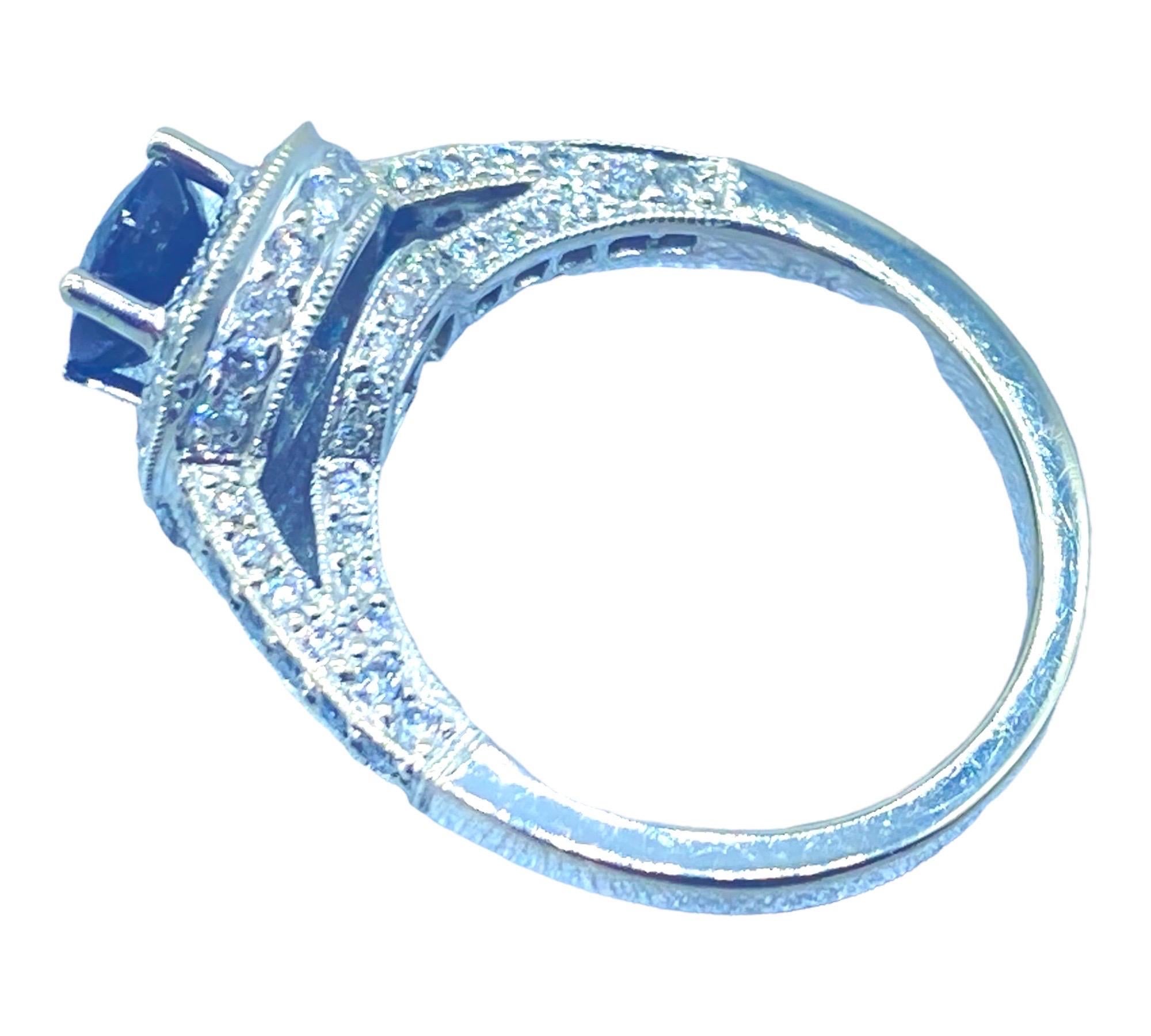 
Lady's 18 karat white gold diamond and sapphire halo ring are 9.90 mm in diameter at the top, with shoulders measuring 2.85 mm. The height of the ring, with an undercarriage of diamonds, is calculated as 9 mm.  The ring size is 6.5

The following
