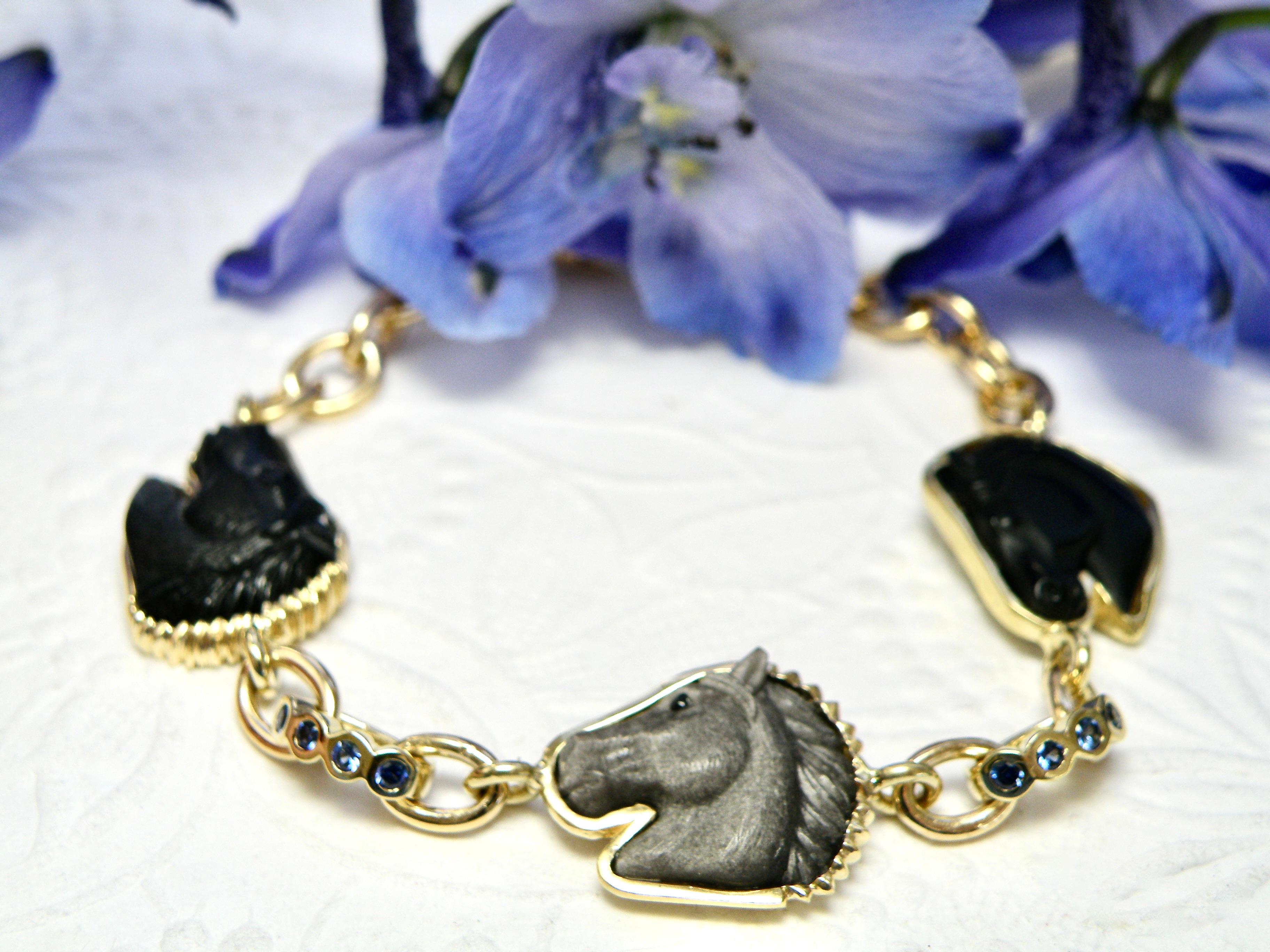 18k, 3 têtes de cheval en onyx sculpté et obsidienne argentée, liens en saphir bleu