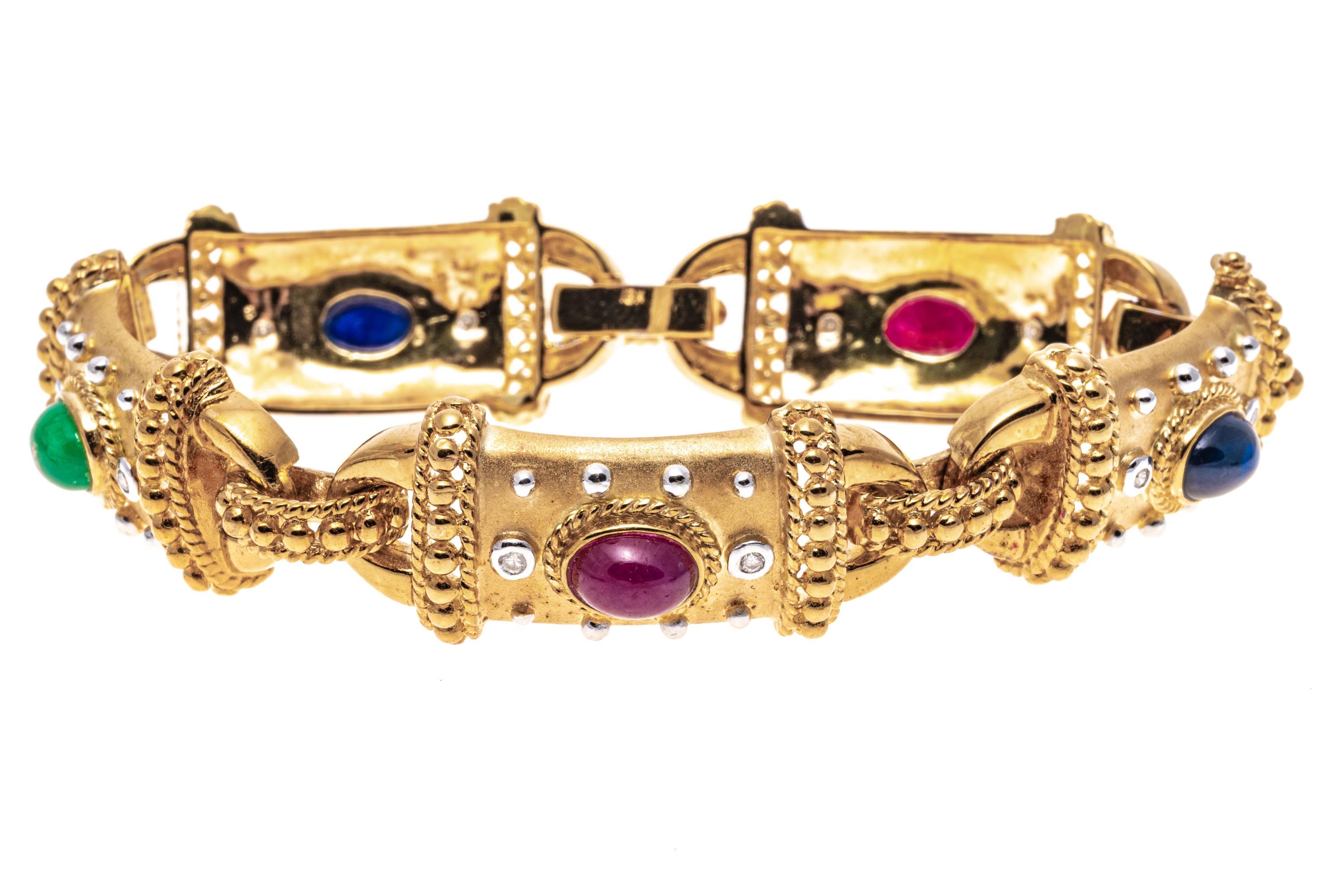 18k Yellow Gold Cabachon Ruby, Emerald, Sapphire And Diamond Link Bracelet.
This gorgeous bracelet is a rectangular link style, with a brushed finish, set with beaded ends, accented with round faceted, bezel set diamonds (approximately 0.15 TCW),