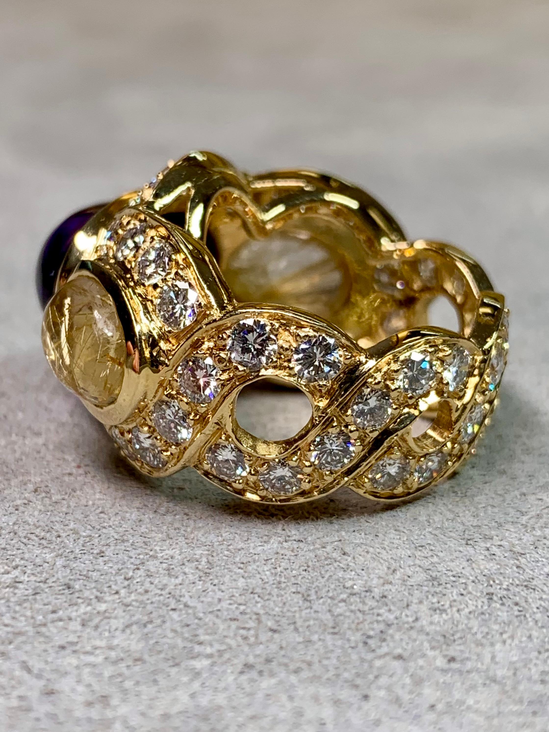 Une bague de cocktail extraordinaire et sculpturale, exécutée de main de maître en or jaune 18 carats et couronnée d'une améthyste cabochon de 6,50 carats richement saturée. La pierre centrale est flanquée de deux cabochons de quartz rutile