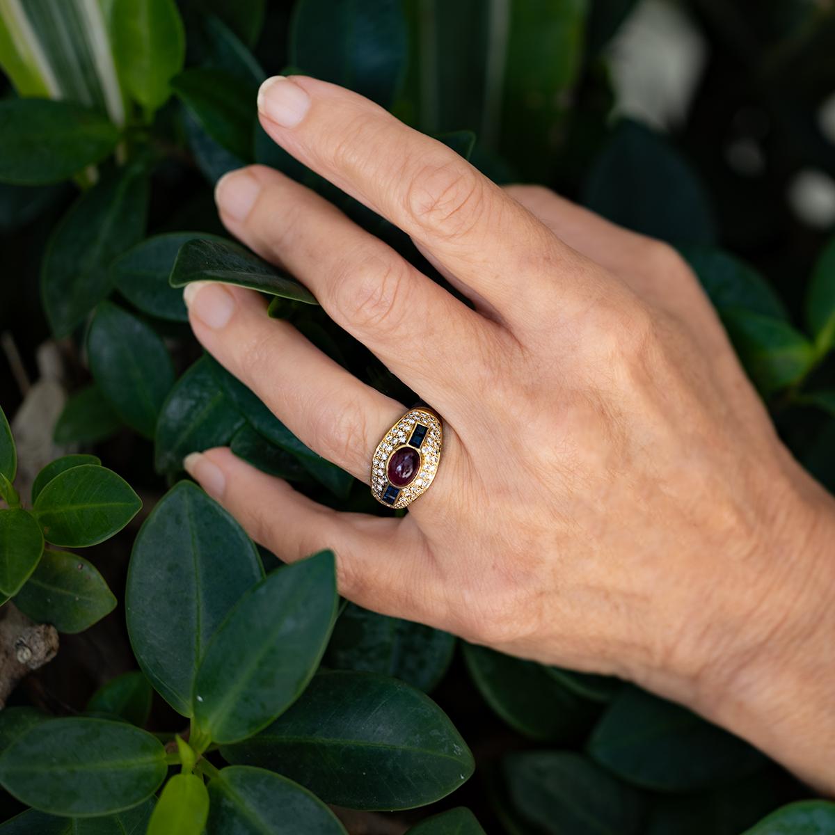 Anello in 18 carati con uno splendido rubino cabochon da 2,77 carati, quattro zaffiri a taglio quadrato per un totale di 0,57 carati e ventotto scintillanti diamanti rotondi per un totale di 0,72 carati, il tutto per un peso di 9,06 grammi.

Anello