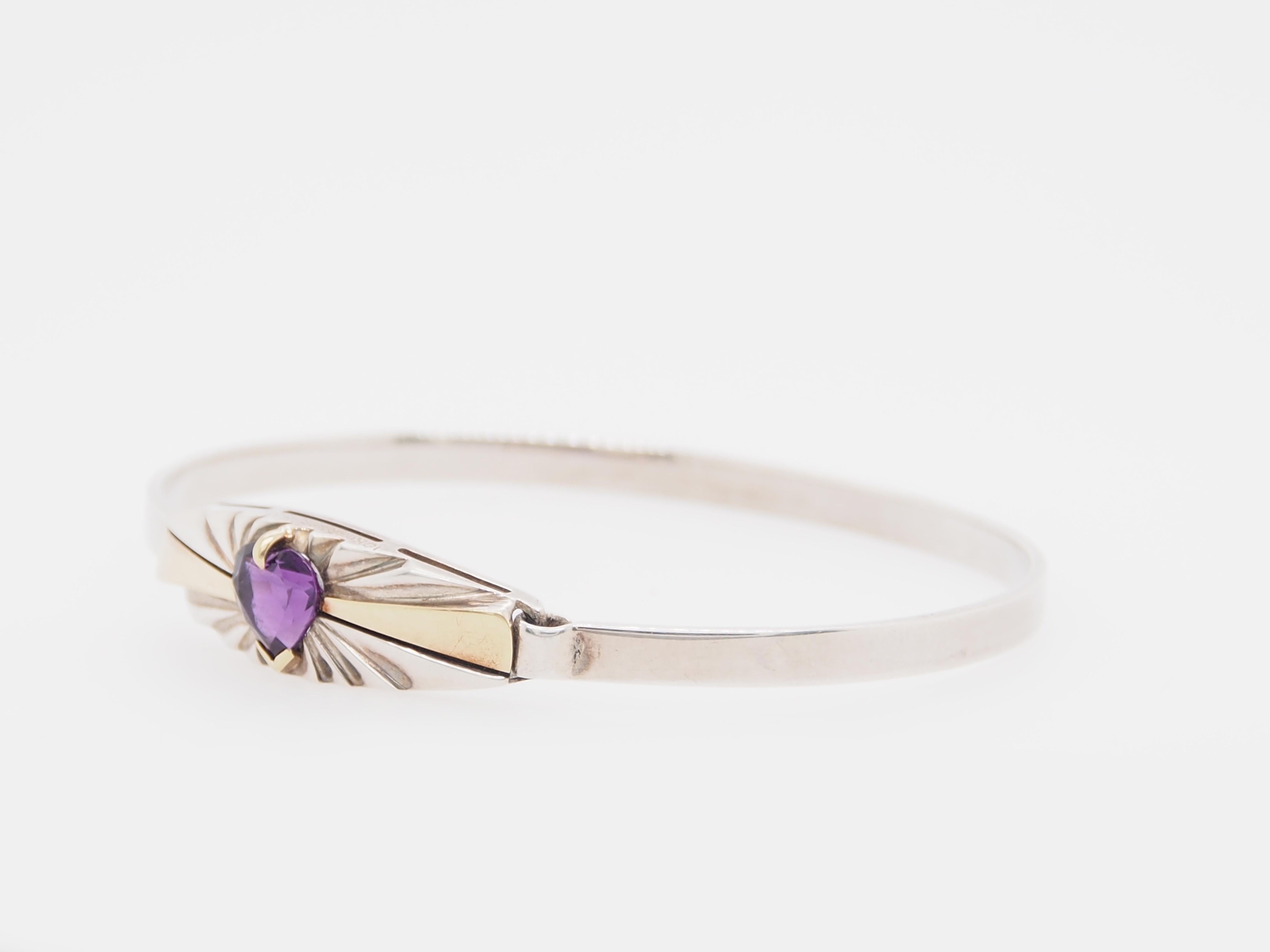 Vintage Cartier 18K Yellow Gold and Silver Bangle. The clasp in enhanced with a Heart Shaped Purple Amethyst. The Bangle measures 6 inches on the inside circumference and the clasp measures 1 1/4 inch in length and 3/8 inch wide. Stamped 