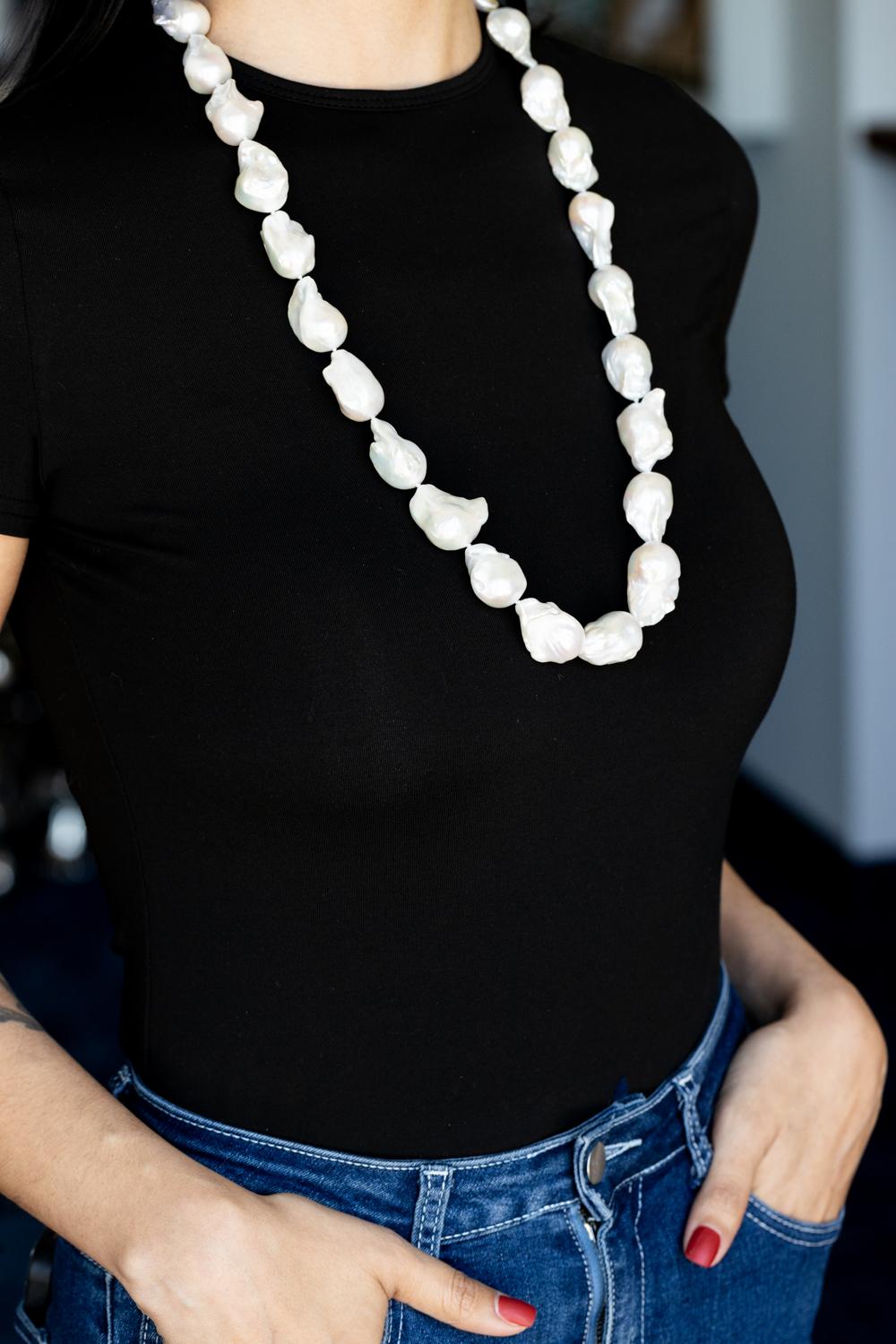 Prova il fascino di un'eleganza senza tempo con questa collana di perle cinesi d'acqua dolce bianche a forma libera. Questo squisito pezzo presenta una serie di perle bianche lucenti, ognuna delle quali ha una forma unica e libera, che cattura la