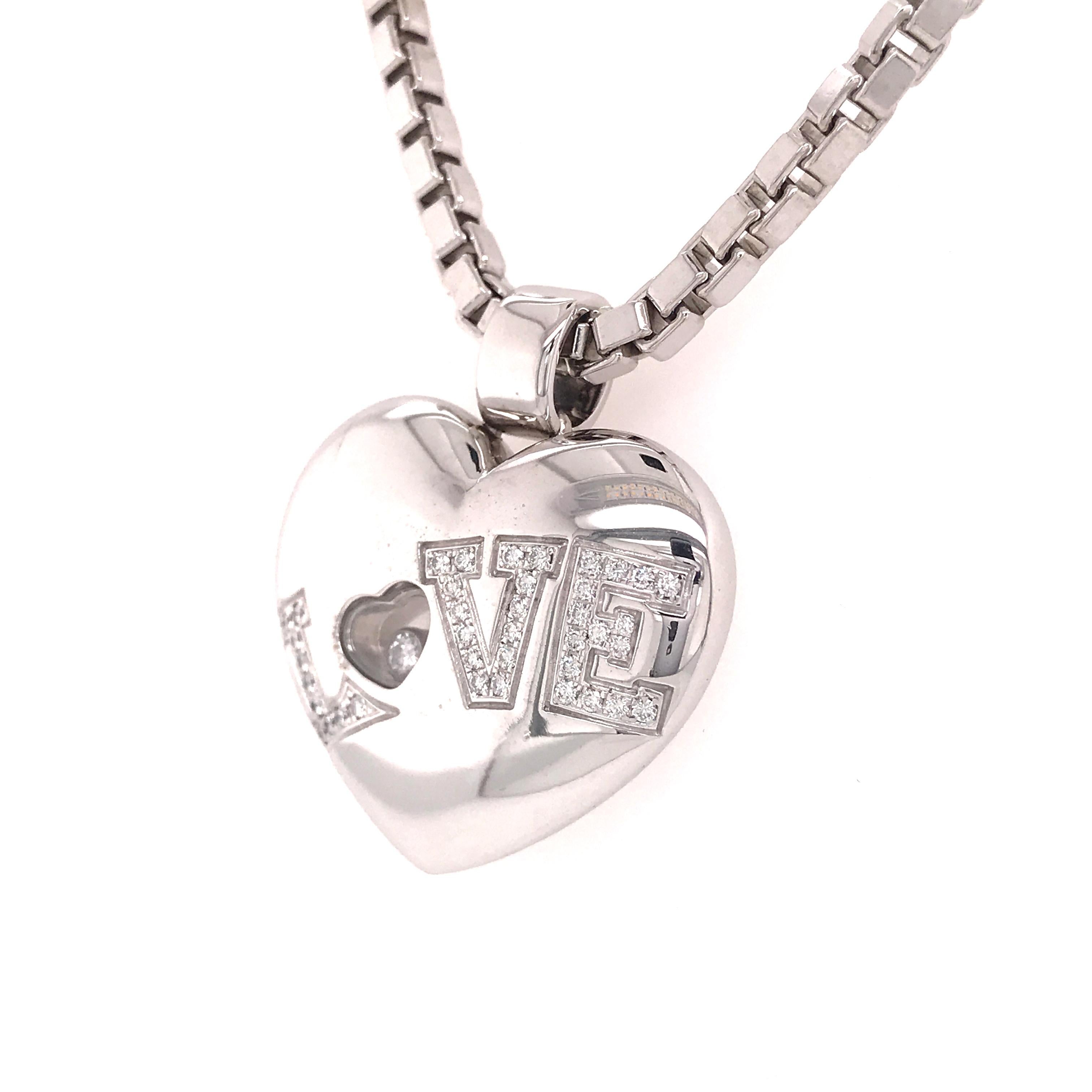 Chopard ‘Love’ Pendant and Chain in 18K White Gold. A heart-shaped pendant with (40) Round Brilliant Cut Diamonds weighing .25 carat total weight, E-F in color and VS in clarity set in letters spelling “Love”, and with a glassed compartment