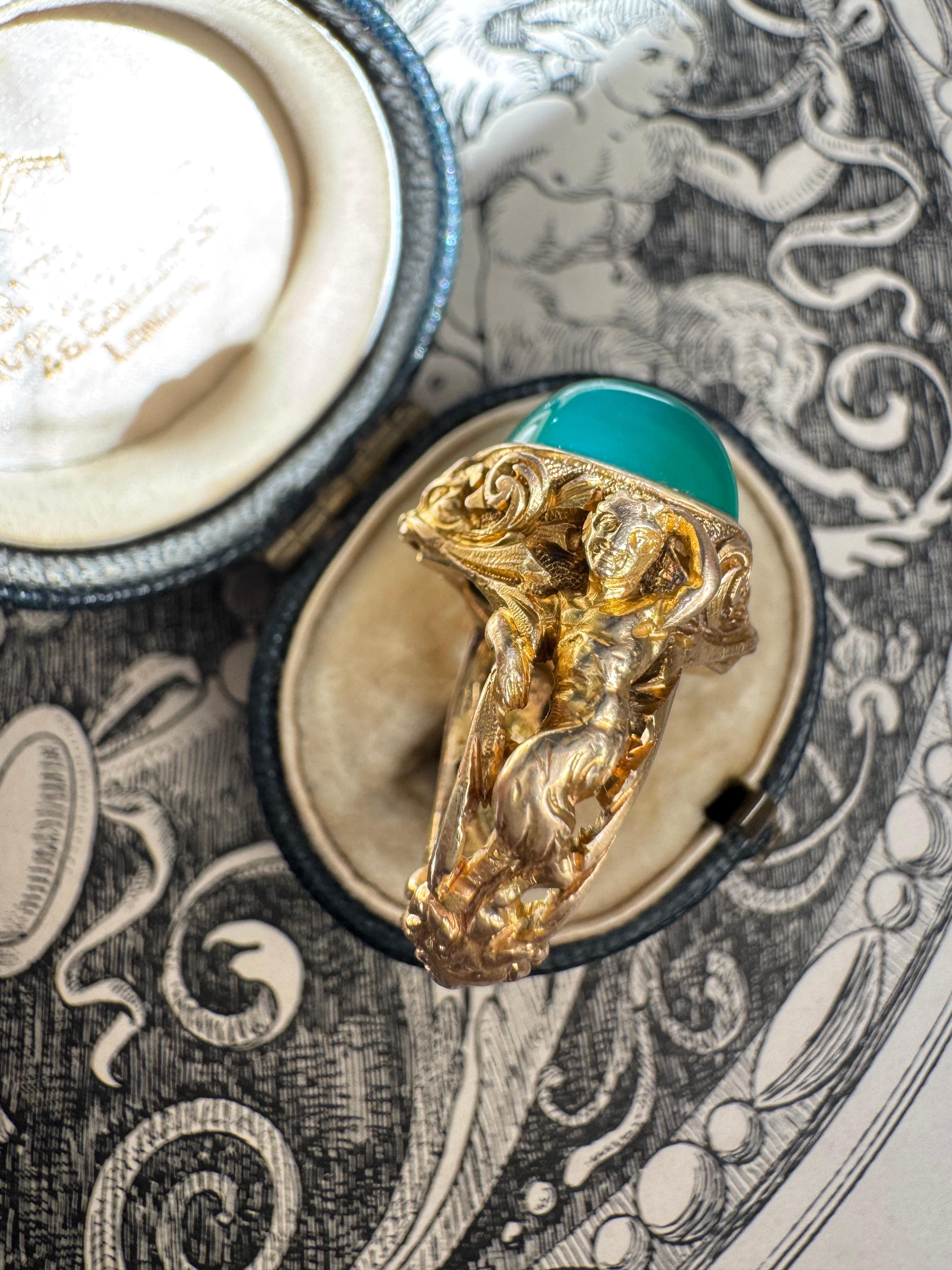 Artfully sculpted with exquisite attention to detail, this striking Classical Revival ring depicts Pan, the mischievous god of the wild, and a Bacchante.

Pan is depicted with the upper body of a man, small horns, goat-like legs and cloven hooves,