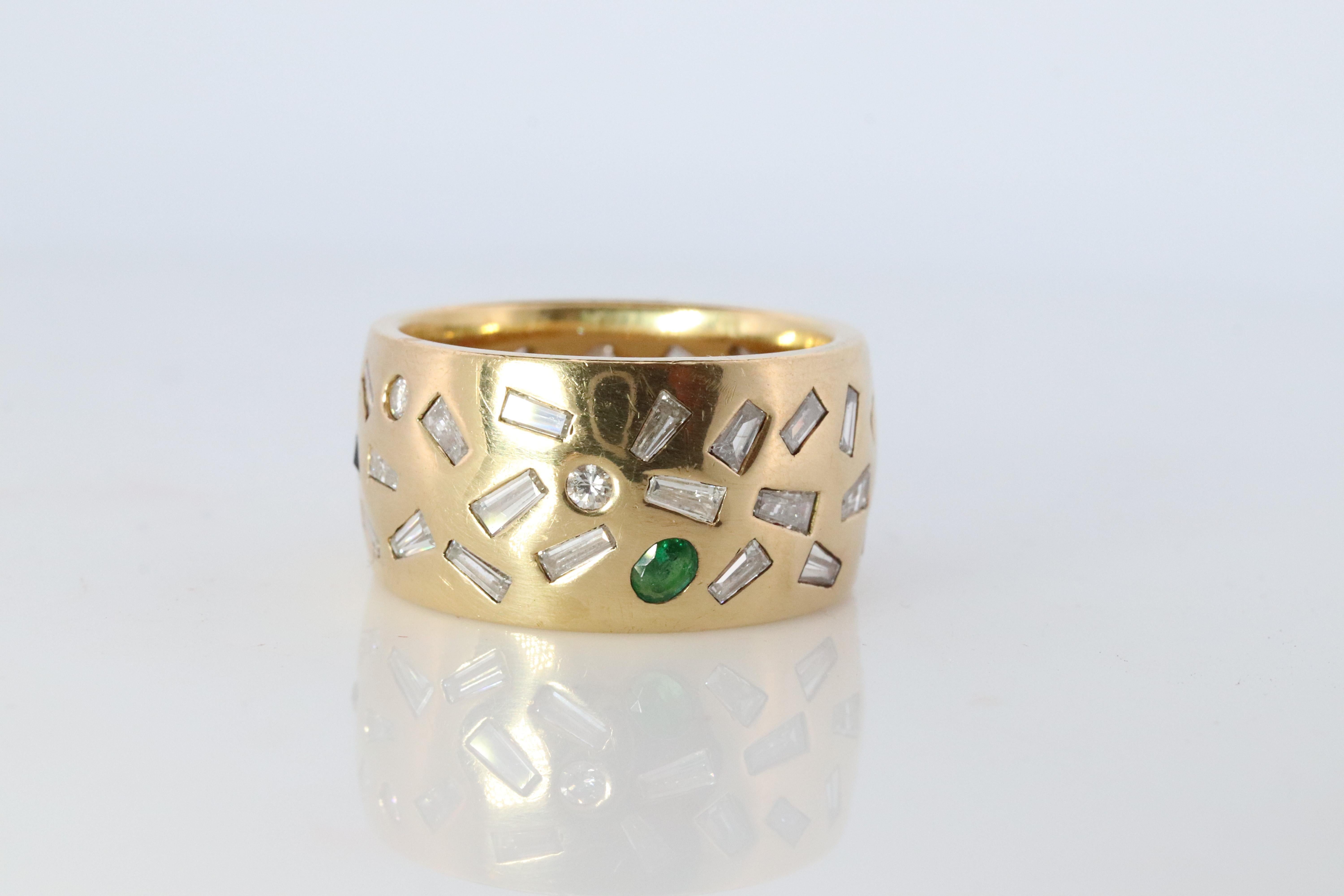 Il sera difficile d'en trouver un autre comme celui-ci.

Bandeau serti de confettis de pierres éparses.

Bandeau large pour cigare.

Or jaune 18k
2.03CTW de diamants baguettes et ronds
0,16ct Rubis naturel
0.15ct Saphir naturel
0,11 Émeraude