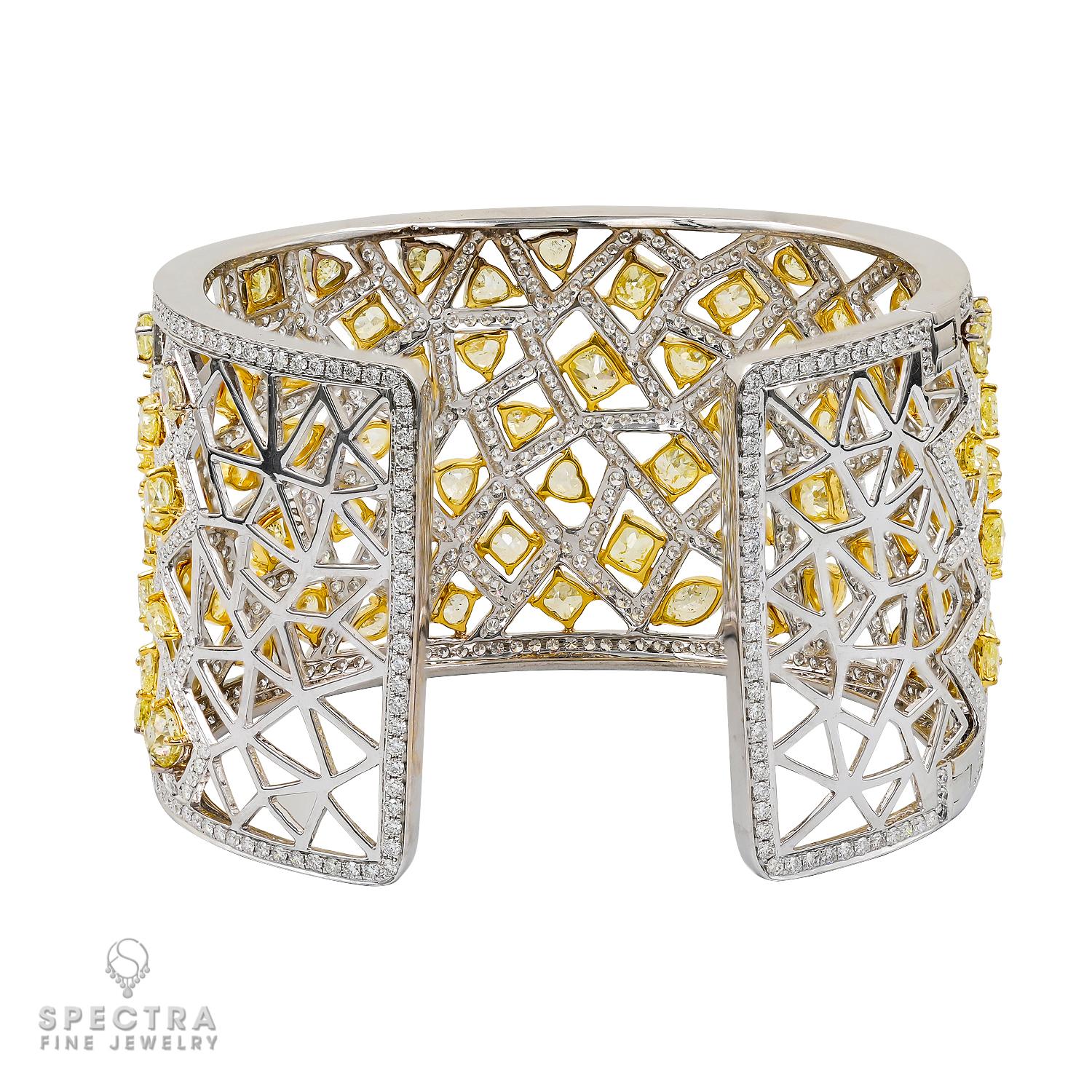 The Contemporary Yellow Diamond Pavé Cuff Bracelet is a stunning piece crafted from 18K yellow and white gold, adorned with a mix of yellow and white diamonds. The 41.79 carats of fancy yellow diamonds, accompanied by Gemologic Laboratory reports,