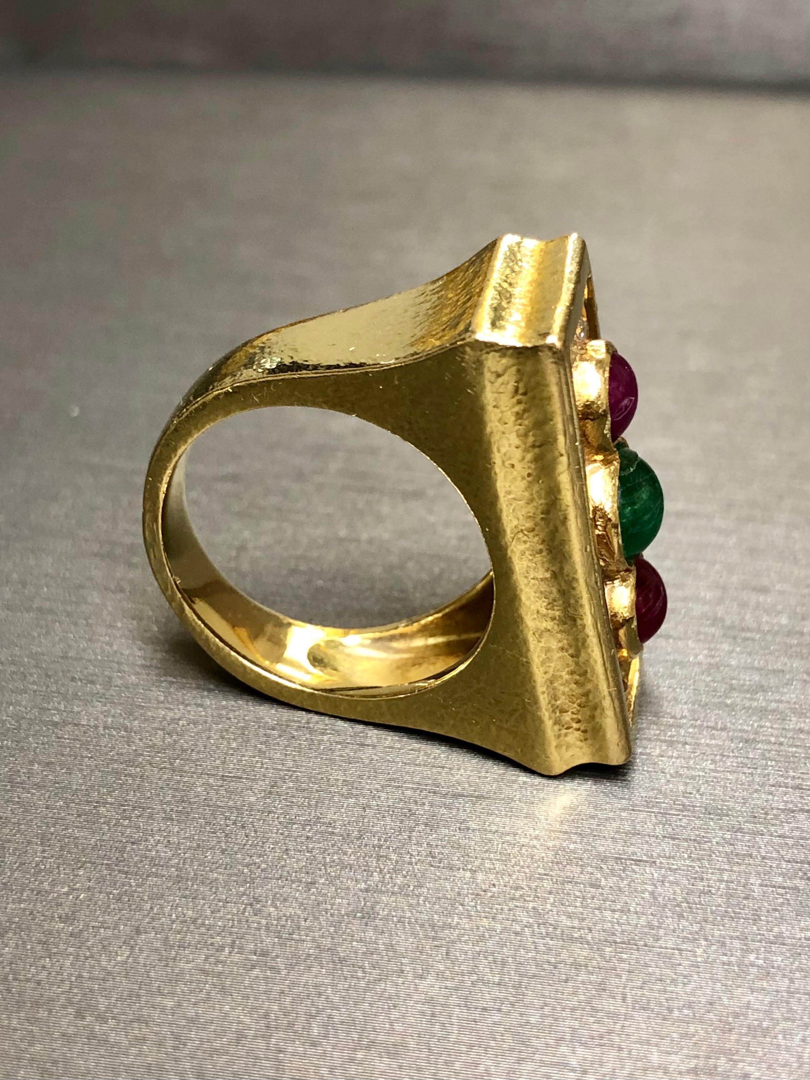 
A name that’s speaks for itself. This original David Webb ring has been done in 18K yellow gold and finished with a hammered texture. The center portion has been set with round and baguette diamonds as well as cabochon rubies and emeralds. A