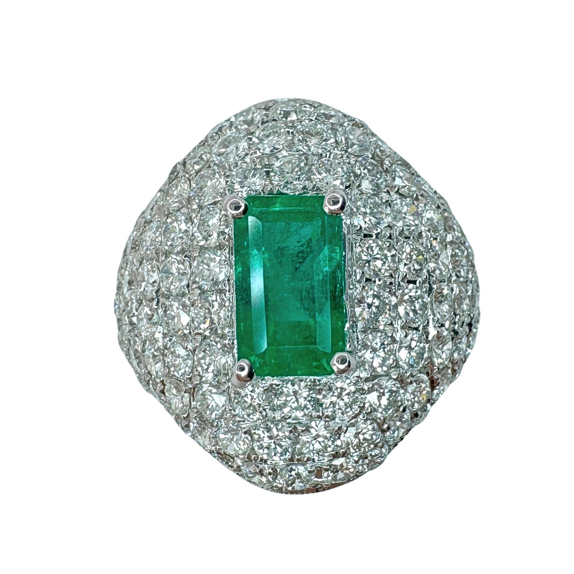 Look at this gem: 18k Diamond and Emerald Ring. Weighing 9.84 grams and sized at 6.25, this ring features a gorgeous 1.46 carat emerald in the center and 2.58 carats of sparkling diamonds surrounding it. Elevate your style and add a touch of luxury