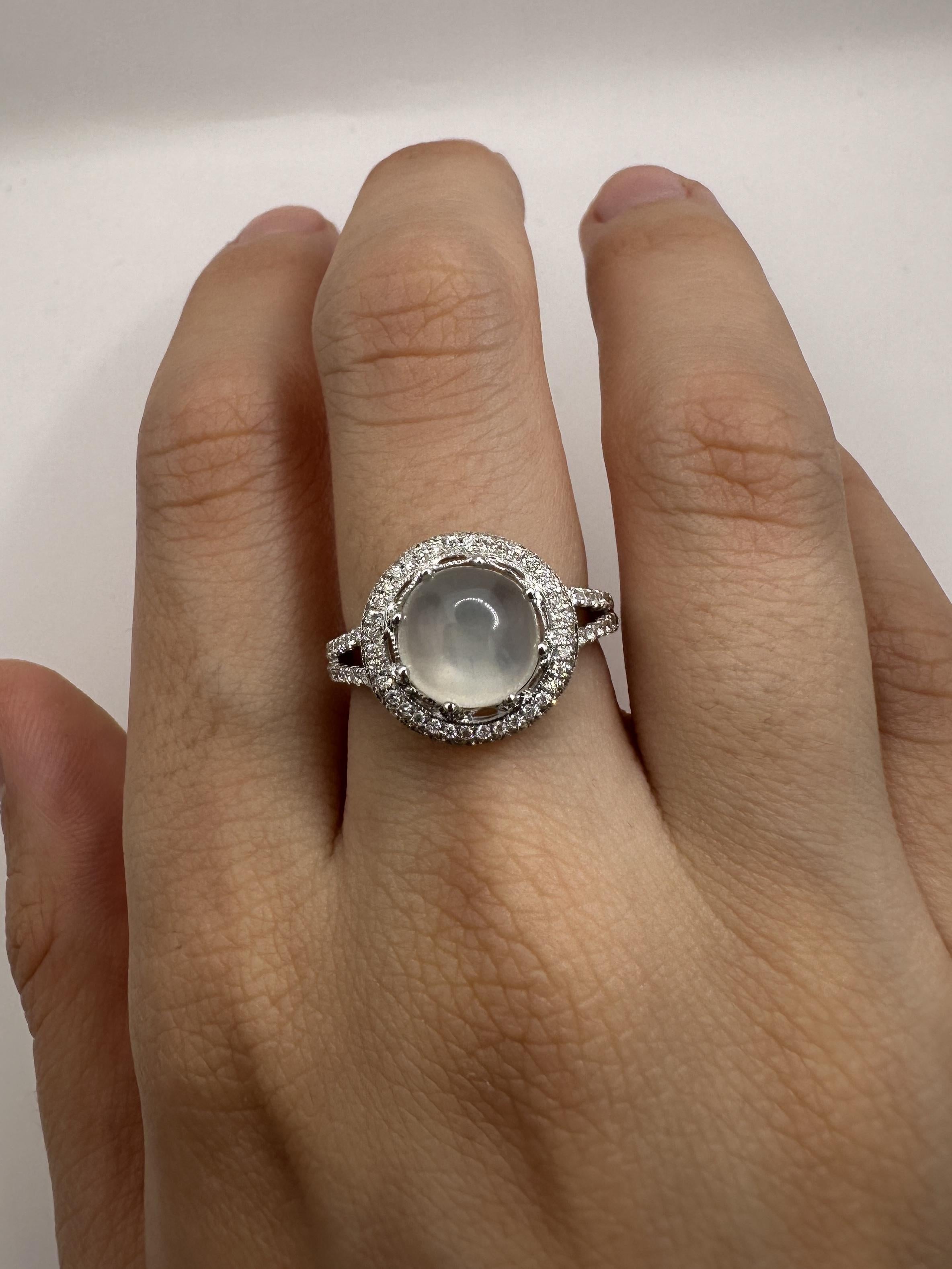 This 18K white gold ring showcases stunning 0.50 carats of diamonds and a mesmerizing 3.24 carat moonstone center. In good condition with only minor surface wear, this ring is sure to add a touch of elegance and sparkle to any outfit. With a weight