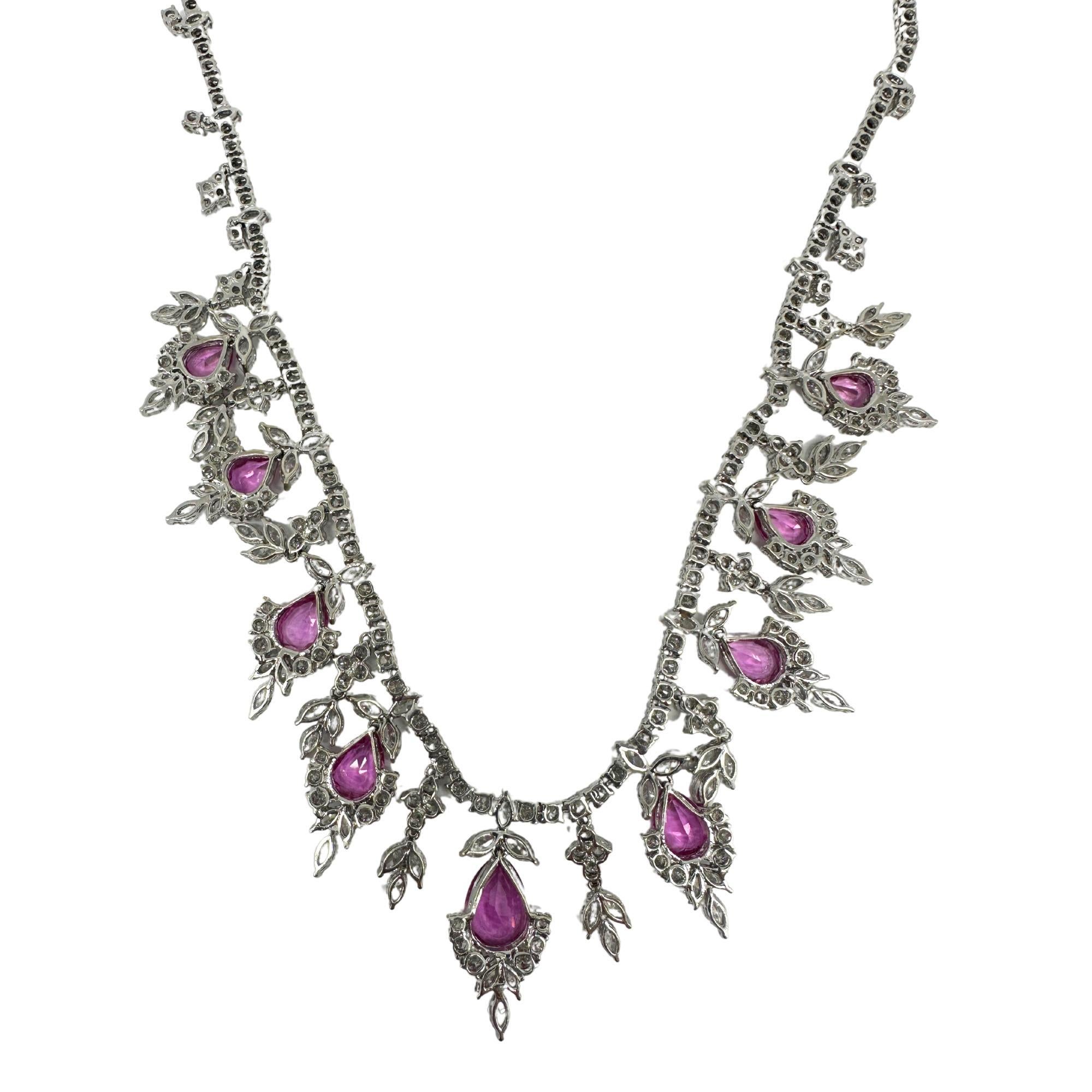 Questa splendida collana in oro bianco 18 carati presenta 11,99 carati di diamanti scintillanti e uno splendido zaffiro rosa a forma di pera del peso di 13,85 carati. In buone condizioni con lievi segni di usura, questo squisito pezzo pesa 49,50