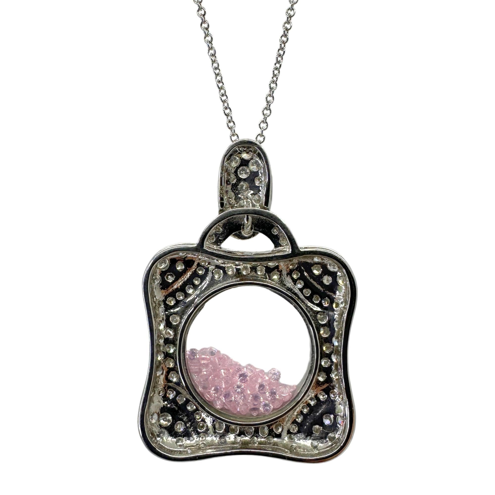 Questo splendido ciondolo shaker con diamanti e zaffiri rosa in 18 carati ha un peso totale di 1,57 carati di diamanti e 7,14 carati di zaffiri rosa. La catena da 18 pollici può essere accorciata a 15,5 pollici e il ciondolo misura 1,5 pollici per 1