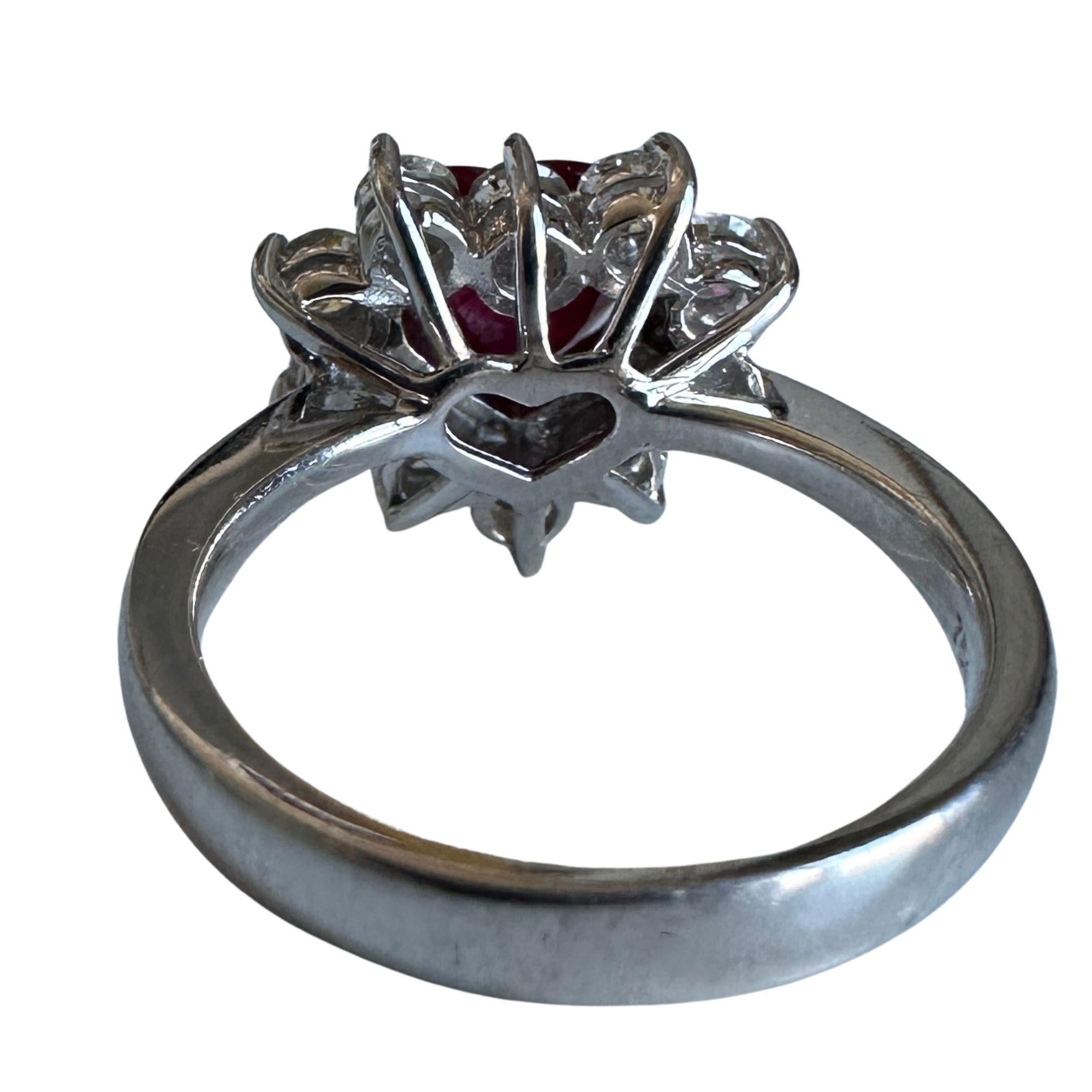 Dieser 18-karätige Ring in Herzform mit Diamanten und Rubinen ist ein wahres Geschenk für jemanden, den Sie lieben, oder um sich selbst zu verwöhnen. Der Rubin in der Mitte des Steins hat 1,61 Karat und ist von einem Halo aus funkelnden Diamanten