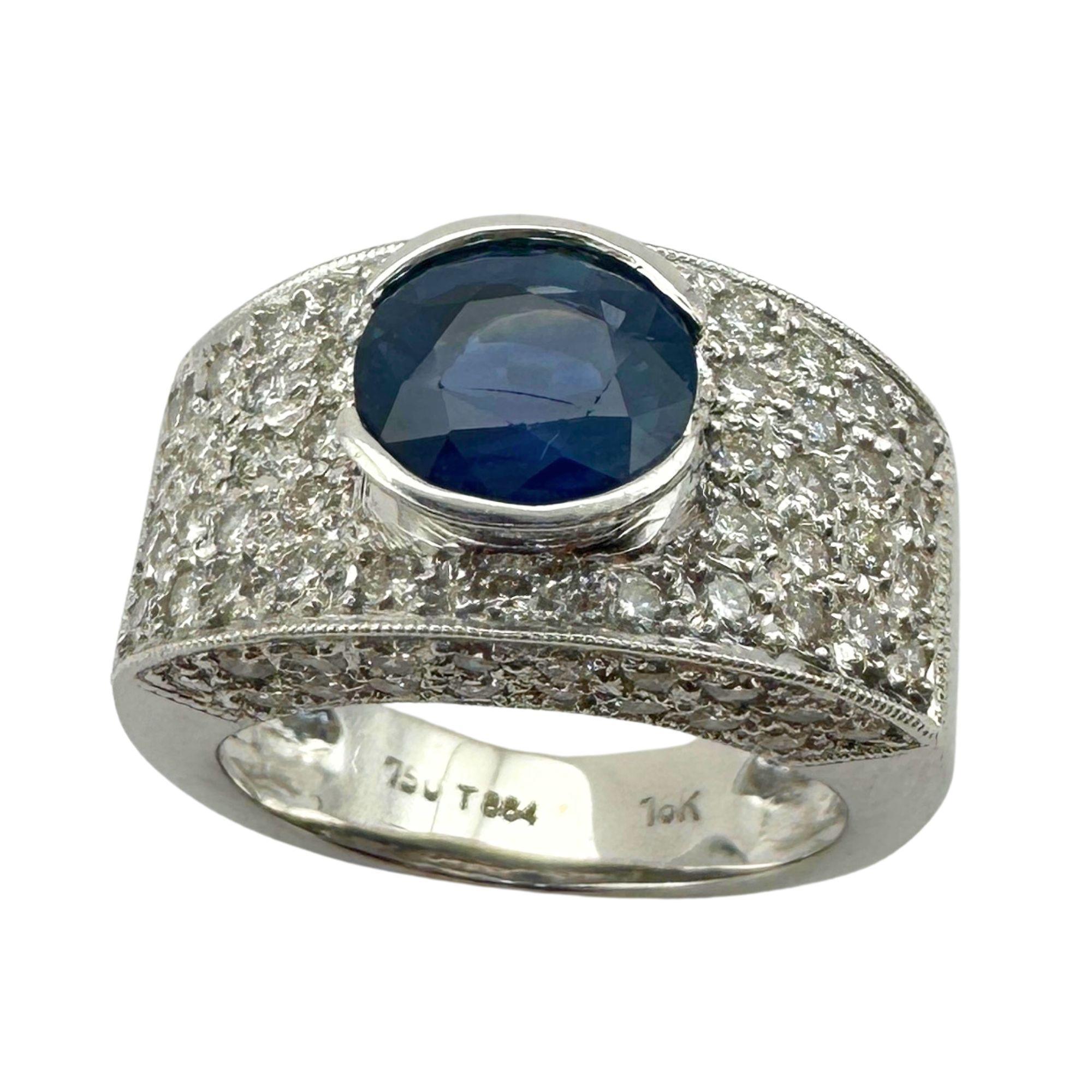 Indulge in luxury with our 18k Diamond and Sapphire Wide Band Ring. Featuring 1.40 carats of sparkling diamonds and a stunning 1.80 carat sapphire center, this sleek and modern ring is crafted in 18k white gold. With a weight of 5.6 grams and a size