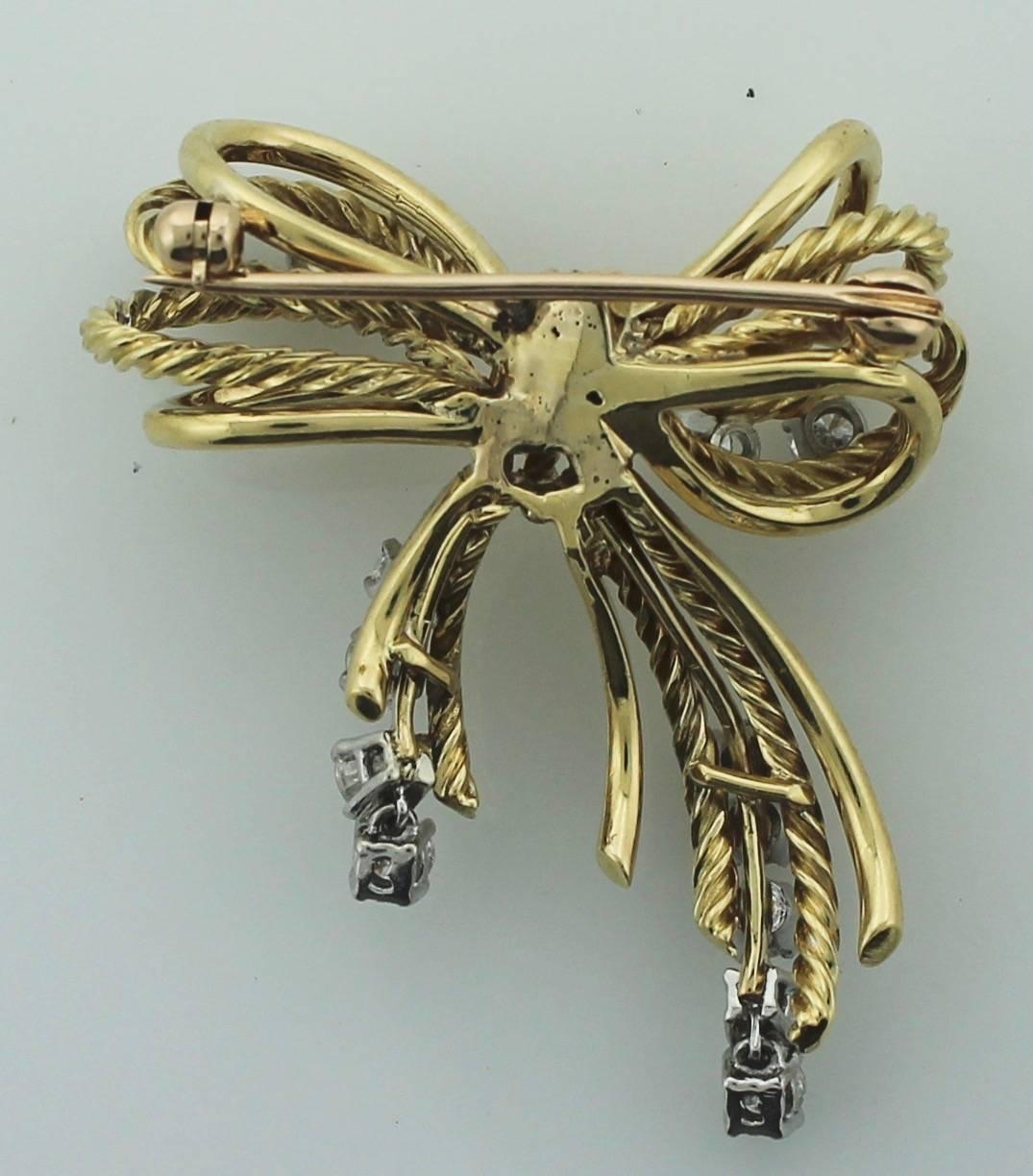 18k Diamond Bow Brooch circa 1950's in yellow and white gold
Fourteen round brilliant cut diamonds contained in the delightful bow style brooch.  Color GH Clarity VVS1-SI1.  If you think the bottom diamonds are hanging funny they are not. In fact