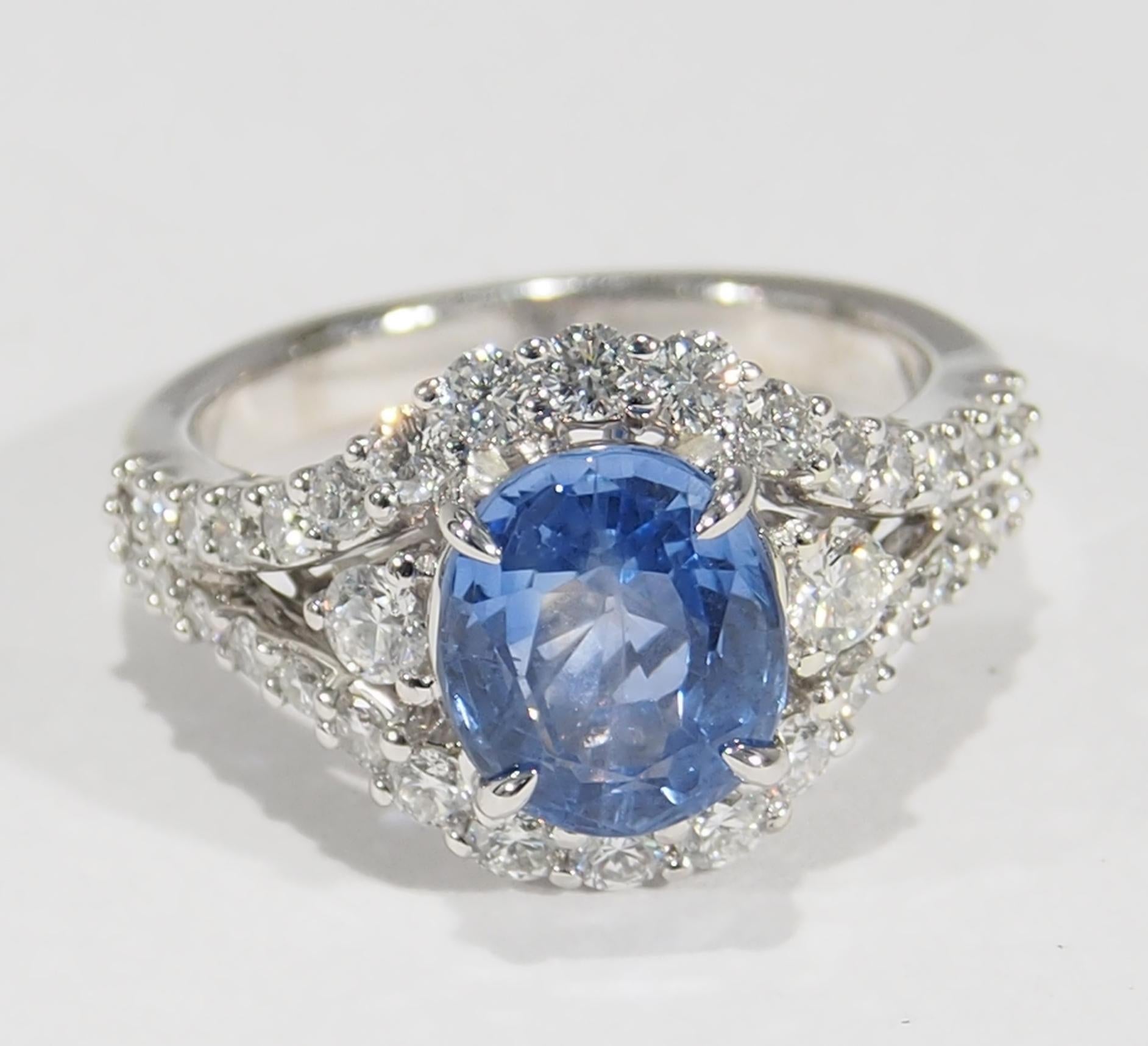 This is a stunning 18K White Gold Sapphire and Diamond Ring. There is a lustrous Ceylon Sapphire, 2.96ct, that is surrounded by (36) Round Brilliant Cut Diamonds, approximately 1.18ctw, G-H in Color, VS in Clarity creating this tantalizing Ring. The