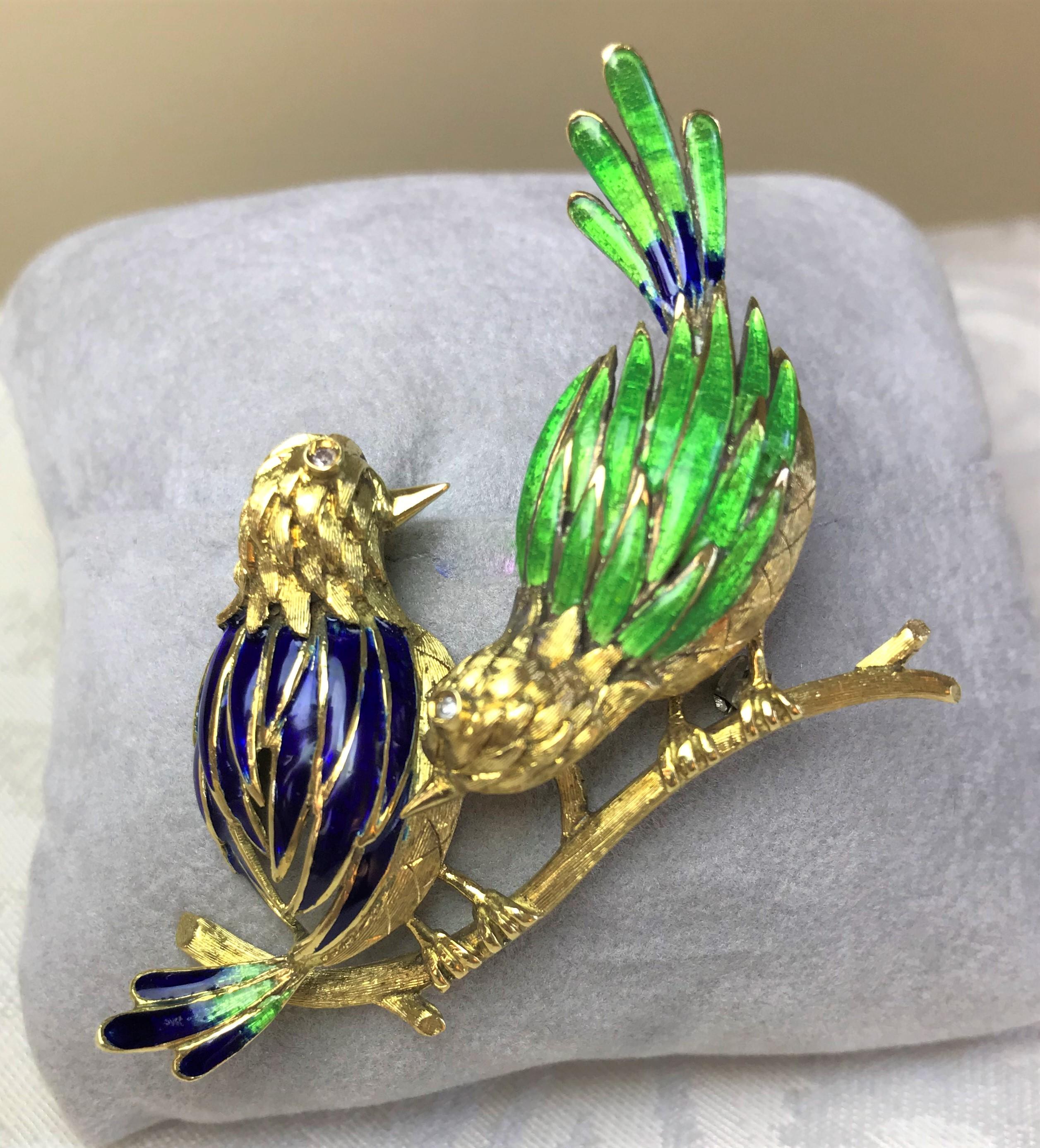 This beautiful two bird brooch is sure to be a conversation starter!
18 karat yellow gold birds on branch perch with lots of detail
One eye per bird with bezel set diamond
Brilliant blue and green enamel
Stamped 