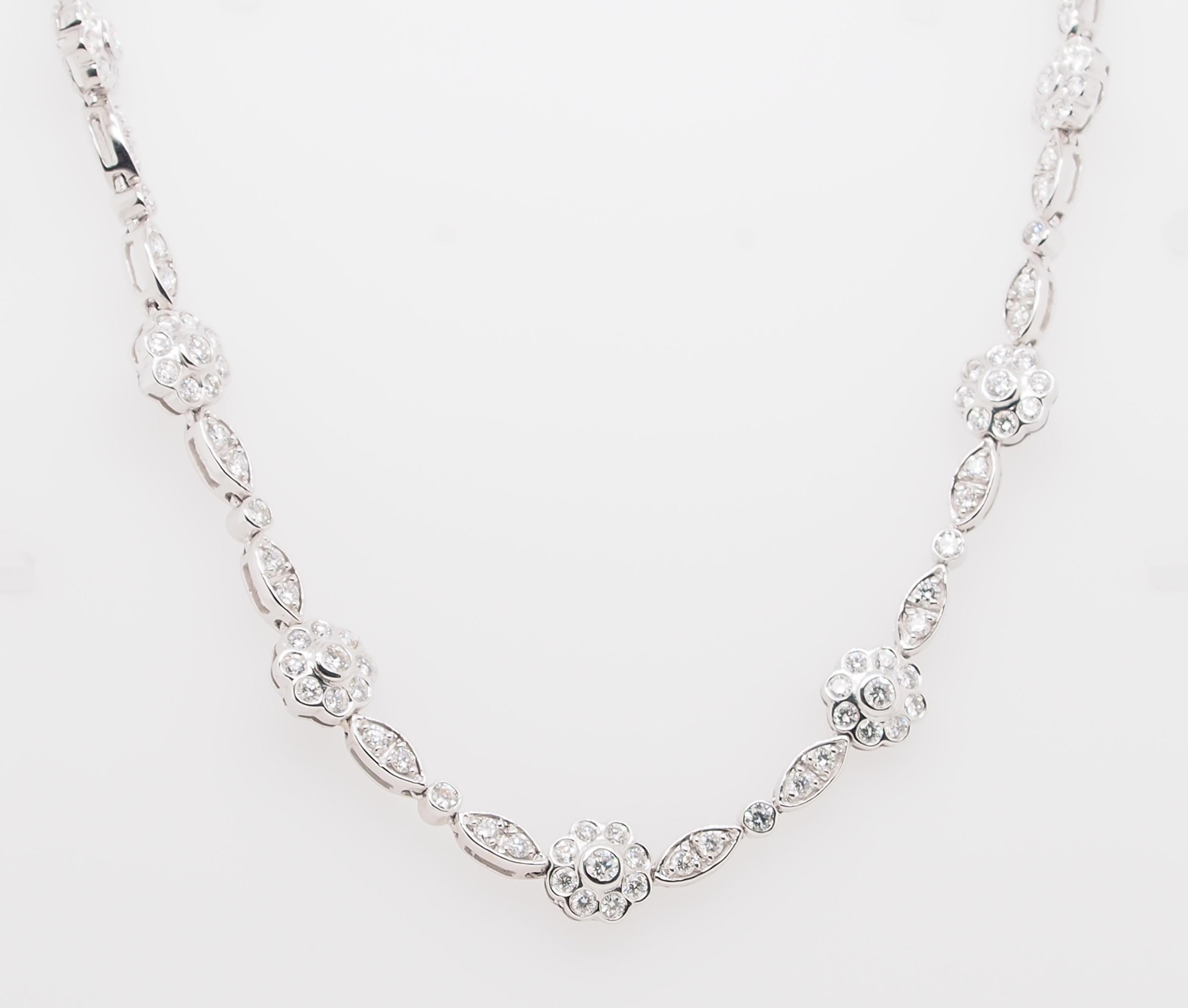 An 18K white gold necklace with 15 Flower clusters, each 3/8 inch in diameter, connected with diamond pave links. 210 Round Brilliant Cut Diamonds 7.75 carat total weight G-H in color, VS in clarity. The necklace is 16 inches and weighs