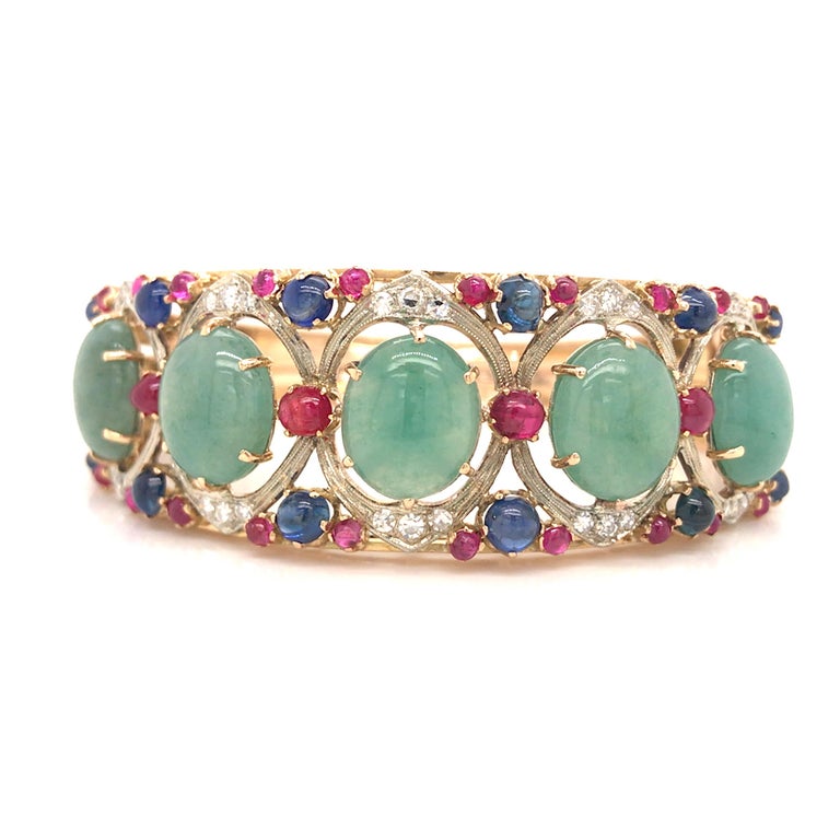 Diamond, Jade, Sapphire, Ruby Bangle Bracelet in 18K Yellow Gold.  (30) Round Brilliant Cut Diamonds weighing 0.55 carat total weight, G-H in color and VS-SI in clarity, (5) Green Jade Stones weighing 25 carats, (12) Sapphire Gemstones weighing 3.03