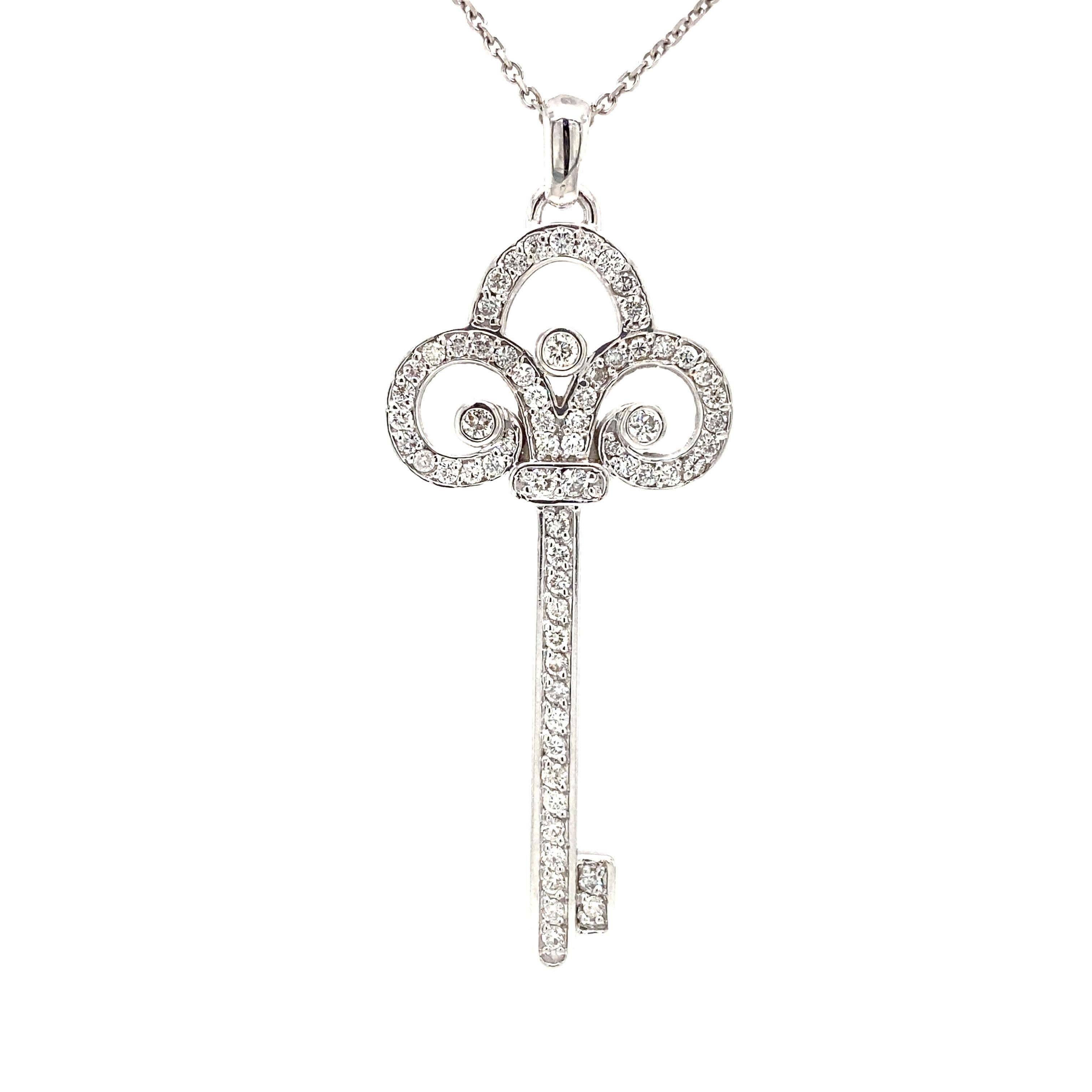 Diamond Key Pendant in 18K White Gold.  (64) Round Brilliant Cut Diamonds weighing 1.50 carat total weight, G-H in color and VS-SI in clarity are expertly set.  The Key measures 2 1/4 inch in length and 1 inch in width.  6.84 grams.  Chain not