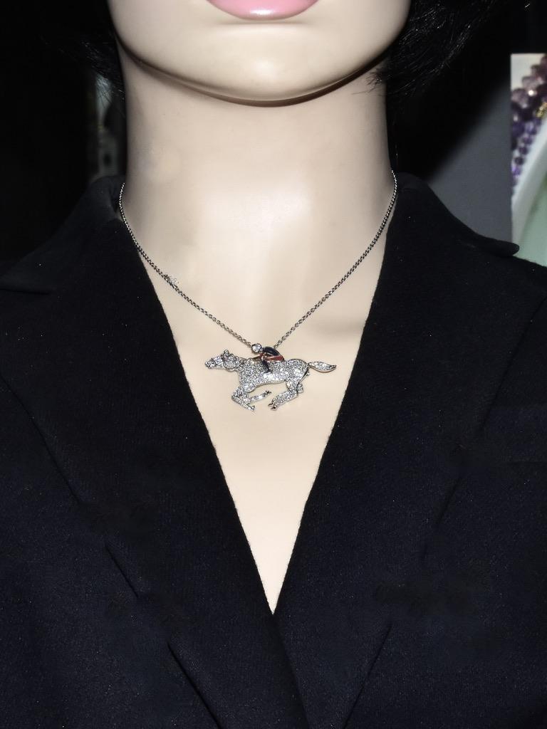 This 18K white gold pendant pave set with white diamonds accented with enamel depicts a cute jockey and even cuter stallion trying ever so hard to win!

This pendant, which can also be worn as a brooch, is well made with 135 brilliant cut diamonds