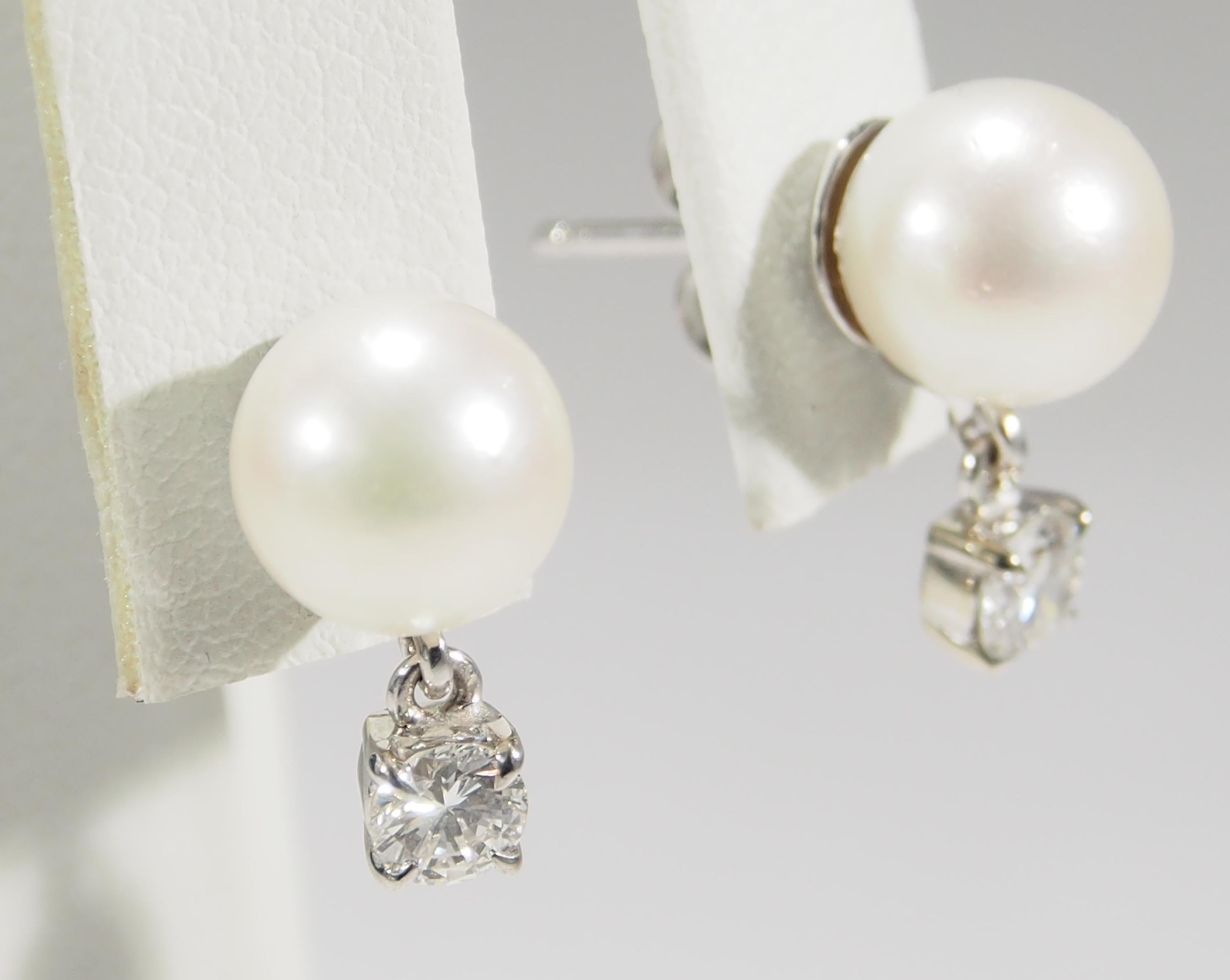 These are a classic pair of 18K White Gold Pearl Stud Earrings. The Pearls measure 8.5mm and are enhanced by (2) Round Brilliant Cut Diamonds, approximately 0.55ctw, G-H in Color, VS-SI in Clarity, Dangling from the lustrous Pearls. The Earrings are
