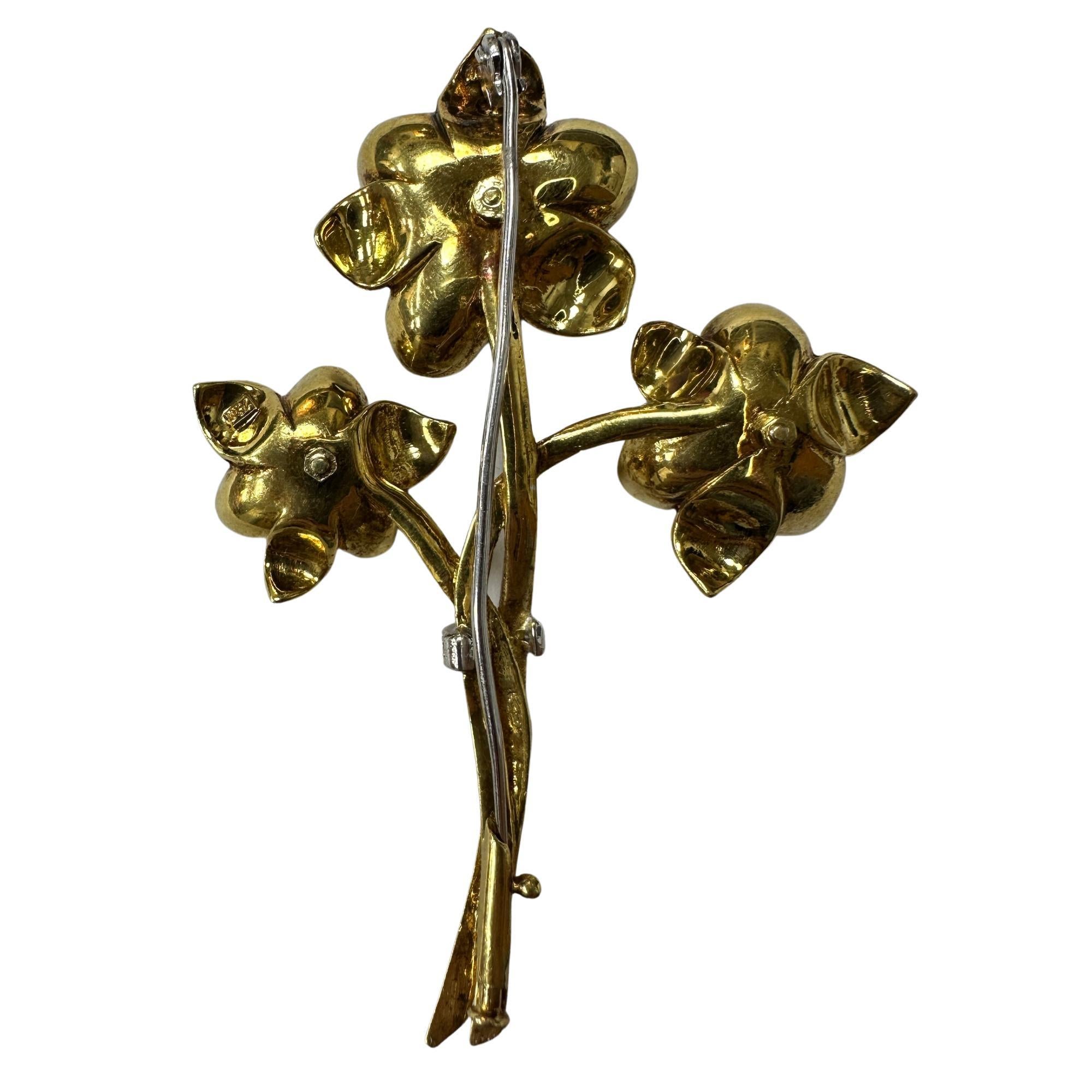 Questa elegante spilla con diamanti e smalto a 18 carati è un pezzo senza tempo che emana raffinatezza e lusso. Con 1,10 carati di diamanti e 0,16 carati di zaffiri, questa spilla aggiungerà sicuramente un tocco di glamour a qualsiasi abbigliamento.