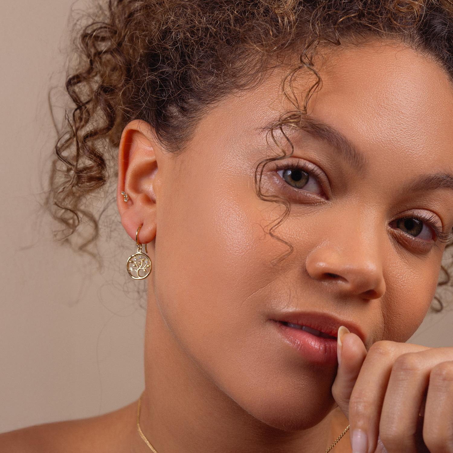These 18k yellow gold Talisman earrings feature a delicately-carved Tree of Life - a long-standing symbol of family, connection and unity. The cut-out delicate tree motif is further decorated with four diamonds in each drop + an extra one in the