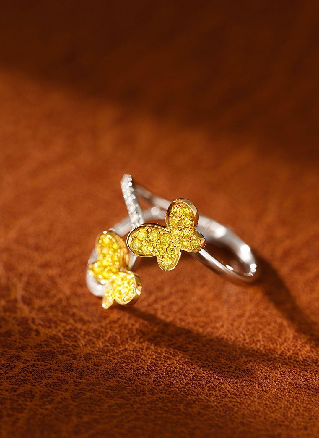 A masterpiece of nature-inspired luxury, this 18K yellow gold double butterfly ring is adorned with brilliant natural diamonds, symbolizing transformation and elegance. The 0.25ct center diamond and 0.12ct side stones are meticulously set to capture