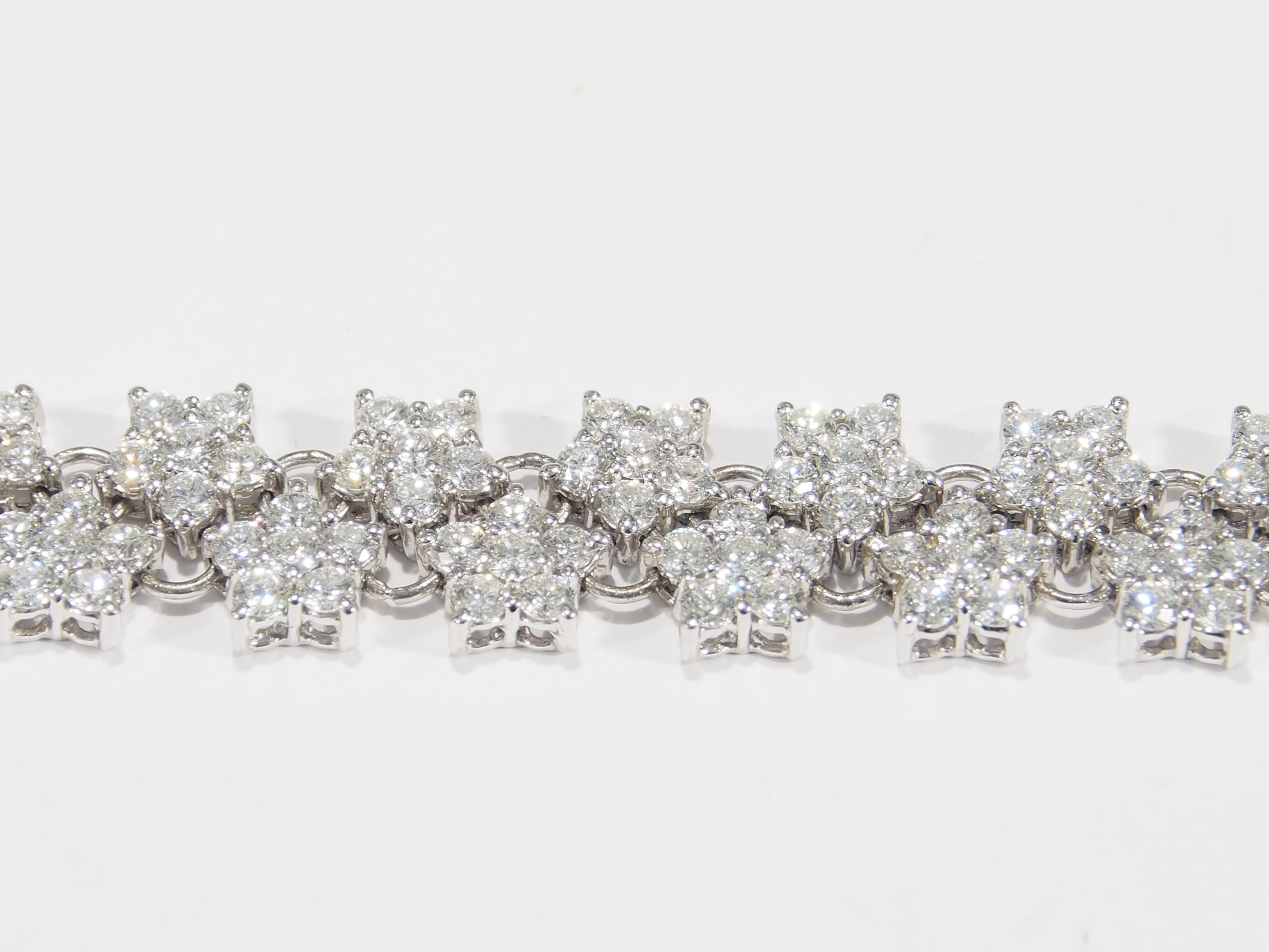 A unique double row Diamond star cluster Tennis Bracelet in 18k White Gold.  Each star is set with (6) Round Brilliant Cut Diamonds and connected with  gold links.  Round Brilliant Cut Diamonds, F-G in color, VS in clarity and weighing a total of