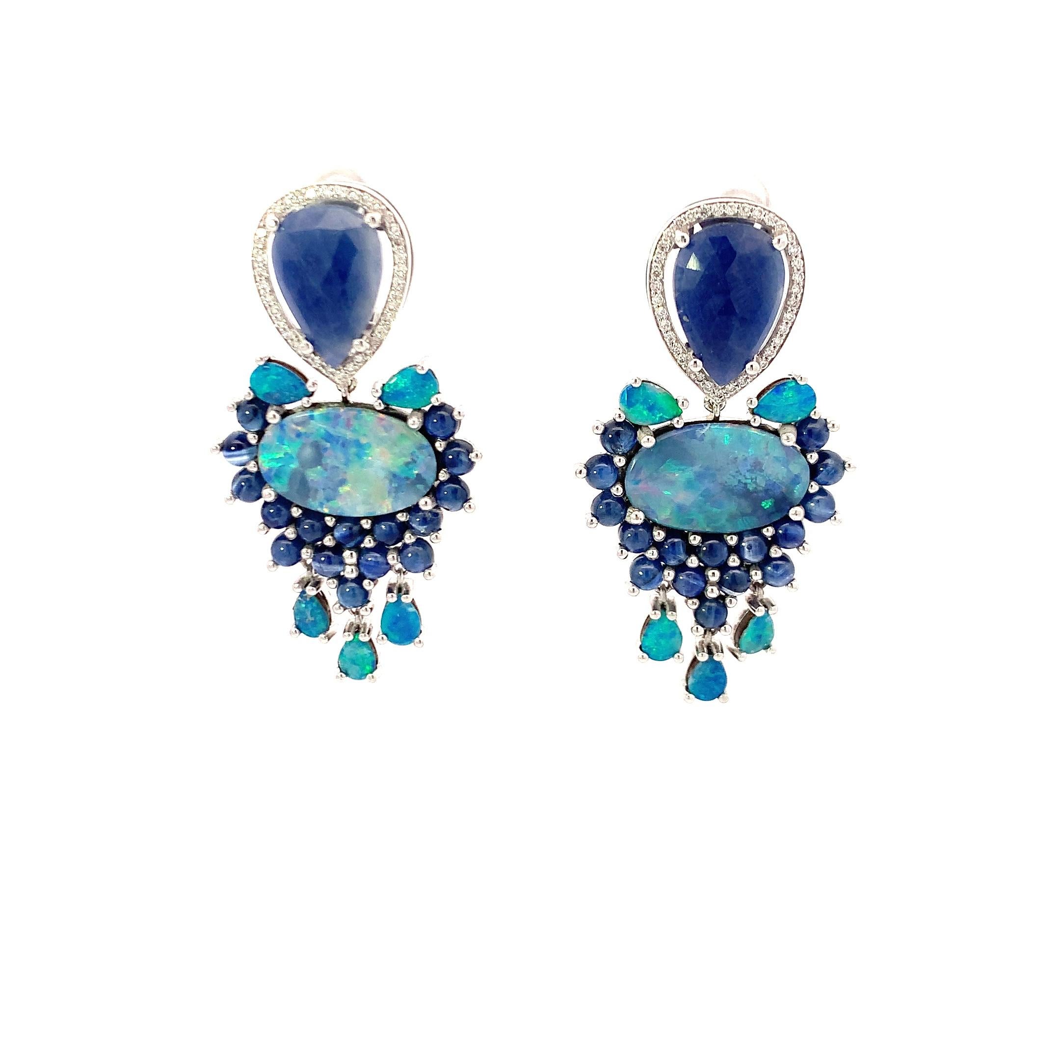 These 18K gold earrings combine the allure of white diamonds, the glow of opal, and the regal hue of blue sapphire into a distinctive design. White diamonds, prized for their brilliance and resilience, serve as a radiant highlight. The opal, known