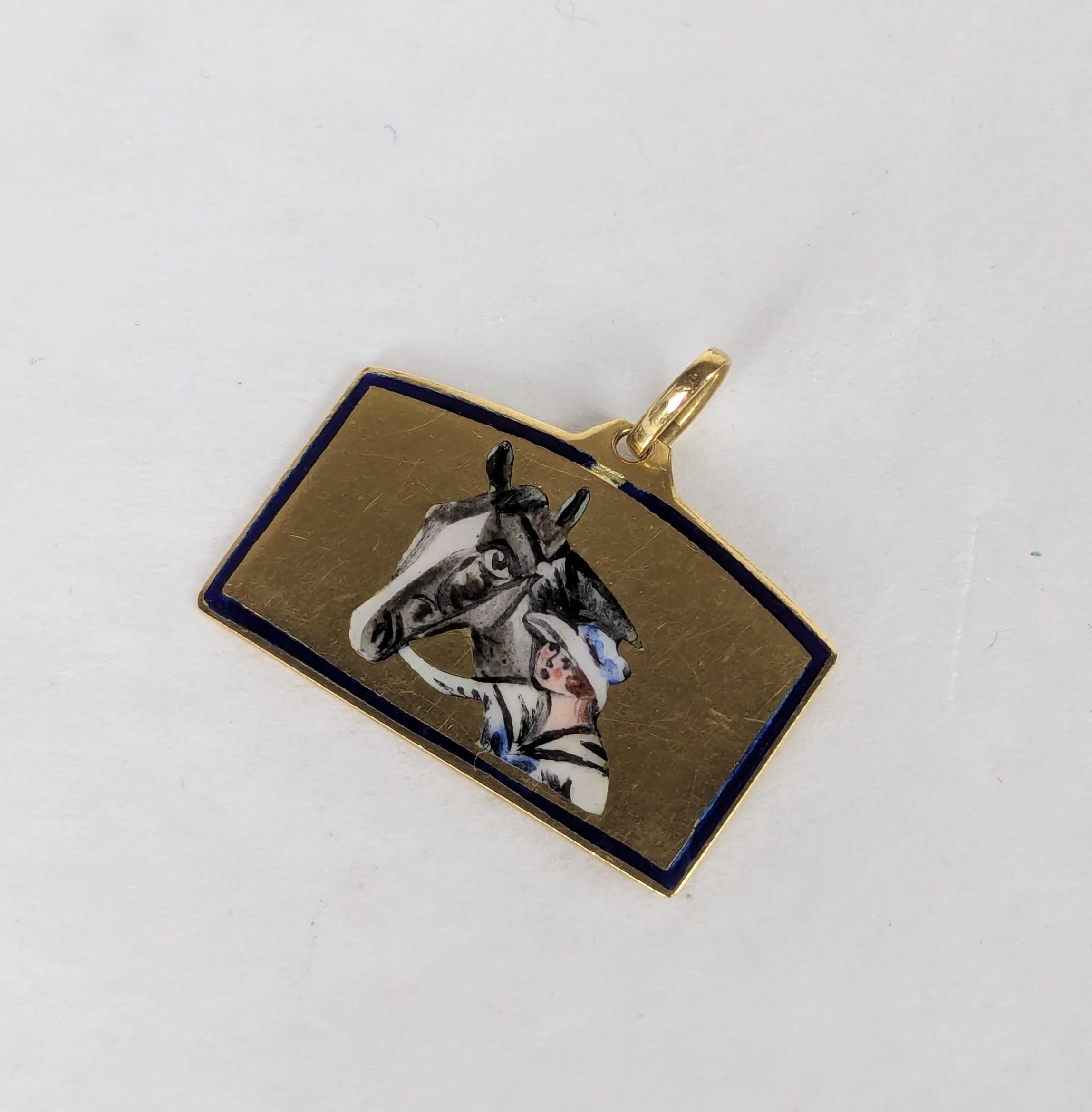 Ciondolo in oro e smalto edoardiano a 18 carati del 1900 circa. Un soggetto affascinante con una giovane cavallerizza in abiti d'epoca che si prende cura del suo cavallo. Bellissimi dettagli. 7/8